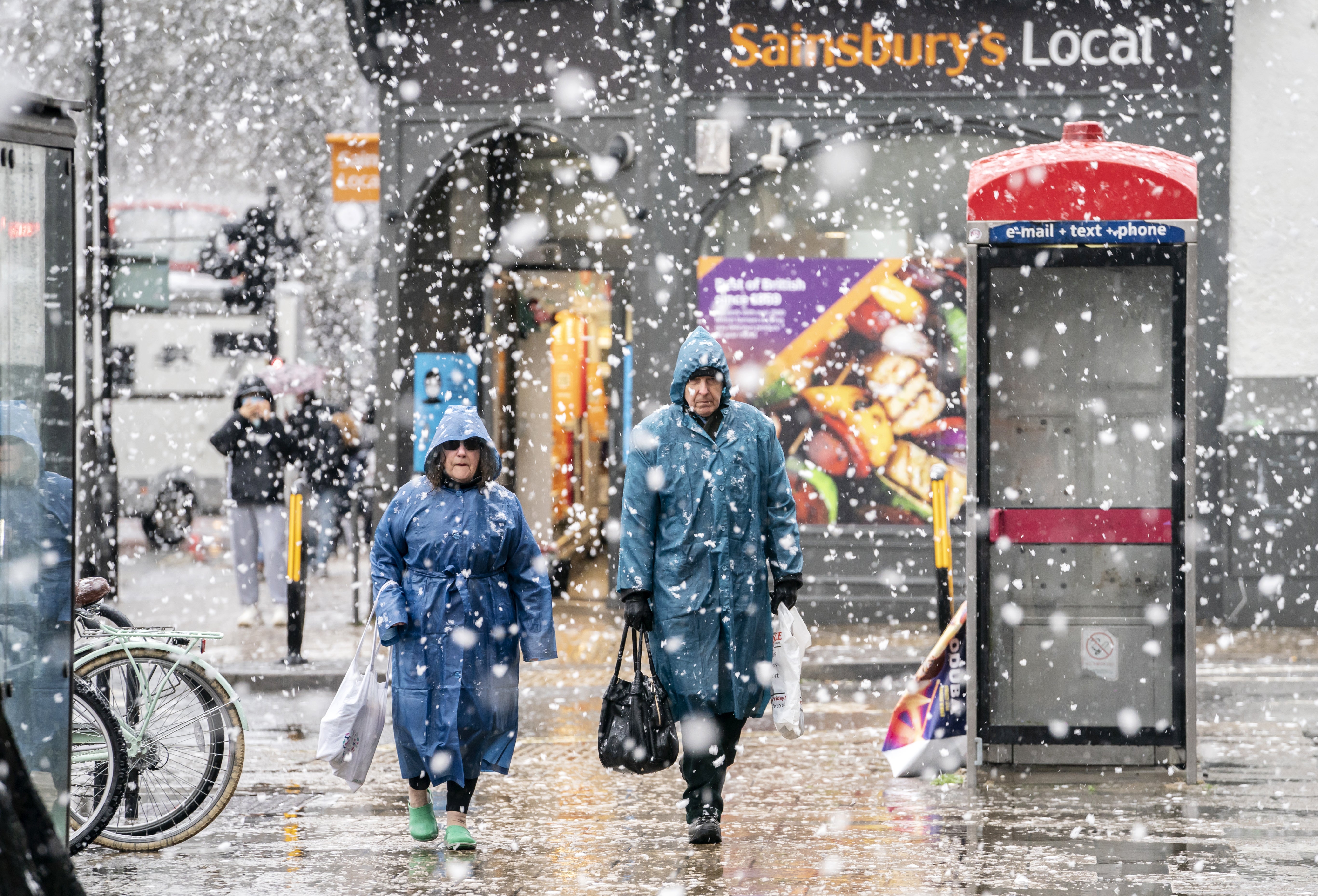 Pedestrians clad in ponchos brave heavy snow in York (Danny Lawson/PA)