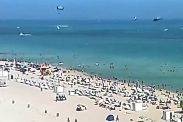 <p>Moments before a helicopter (top right) crashed with three on board into the water off Miami’s famous South Beach on Saturday</p>