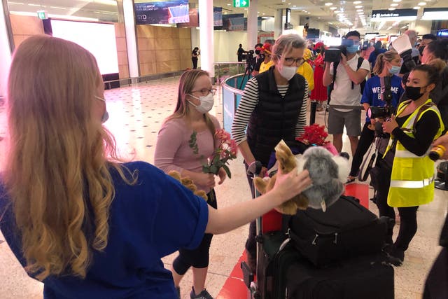<p>Welcome back: the first passengers to arrive in Sydney after the travel ban lifted were showered with local gifts</p>