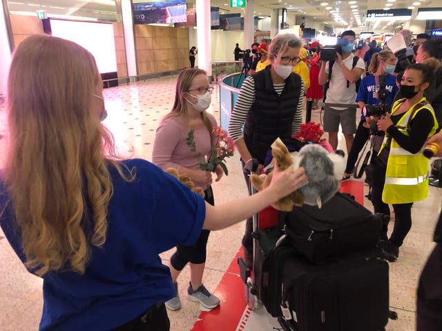 <p>Welcome back: the first passengers to arrive in Sydney after the travel ban lifted were showered with local gifts</p>