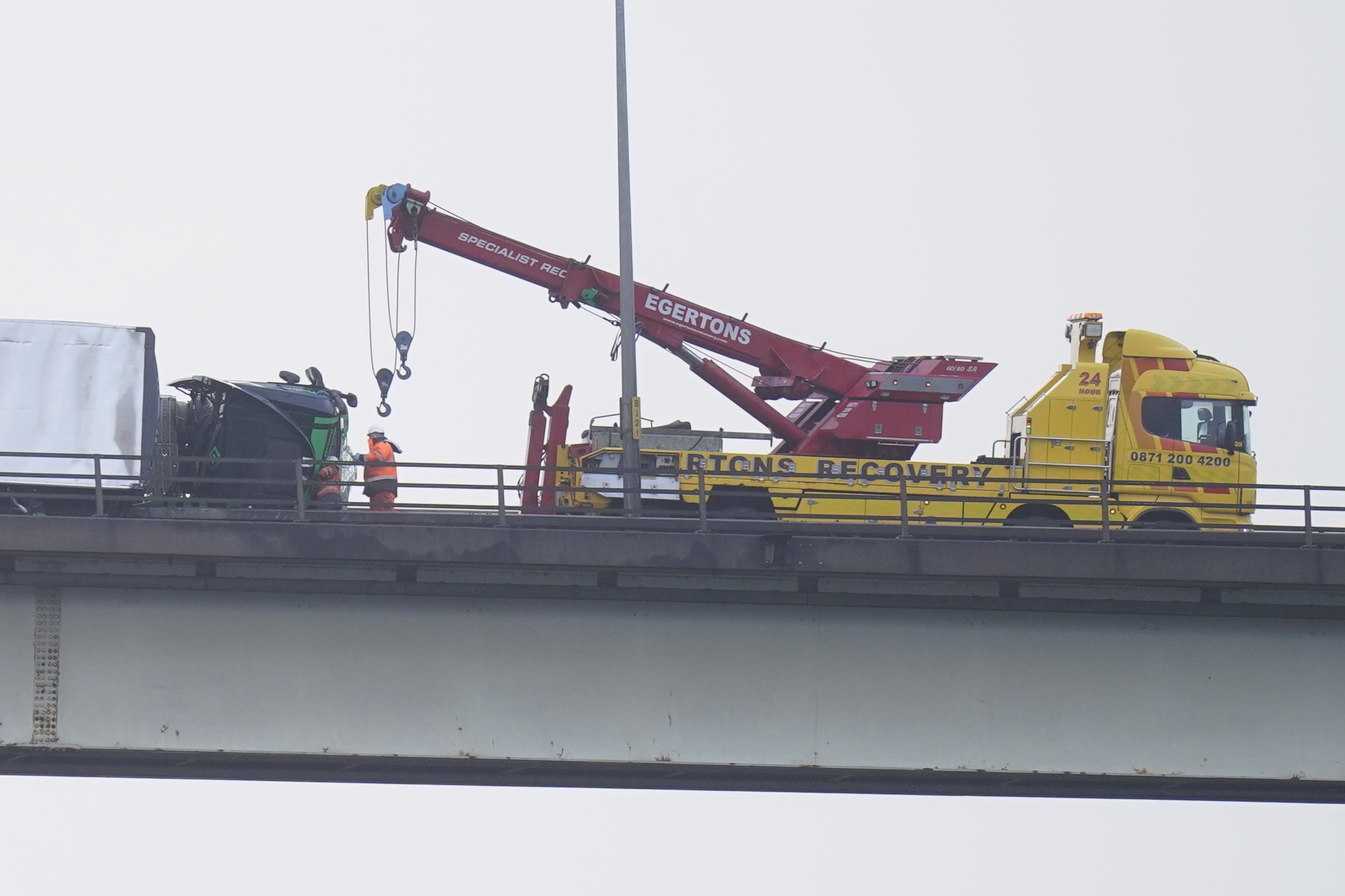An overturned vehicle is removed on the M60, near Trafford Park in Manchester as Storm Franklin moved in overnight.