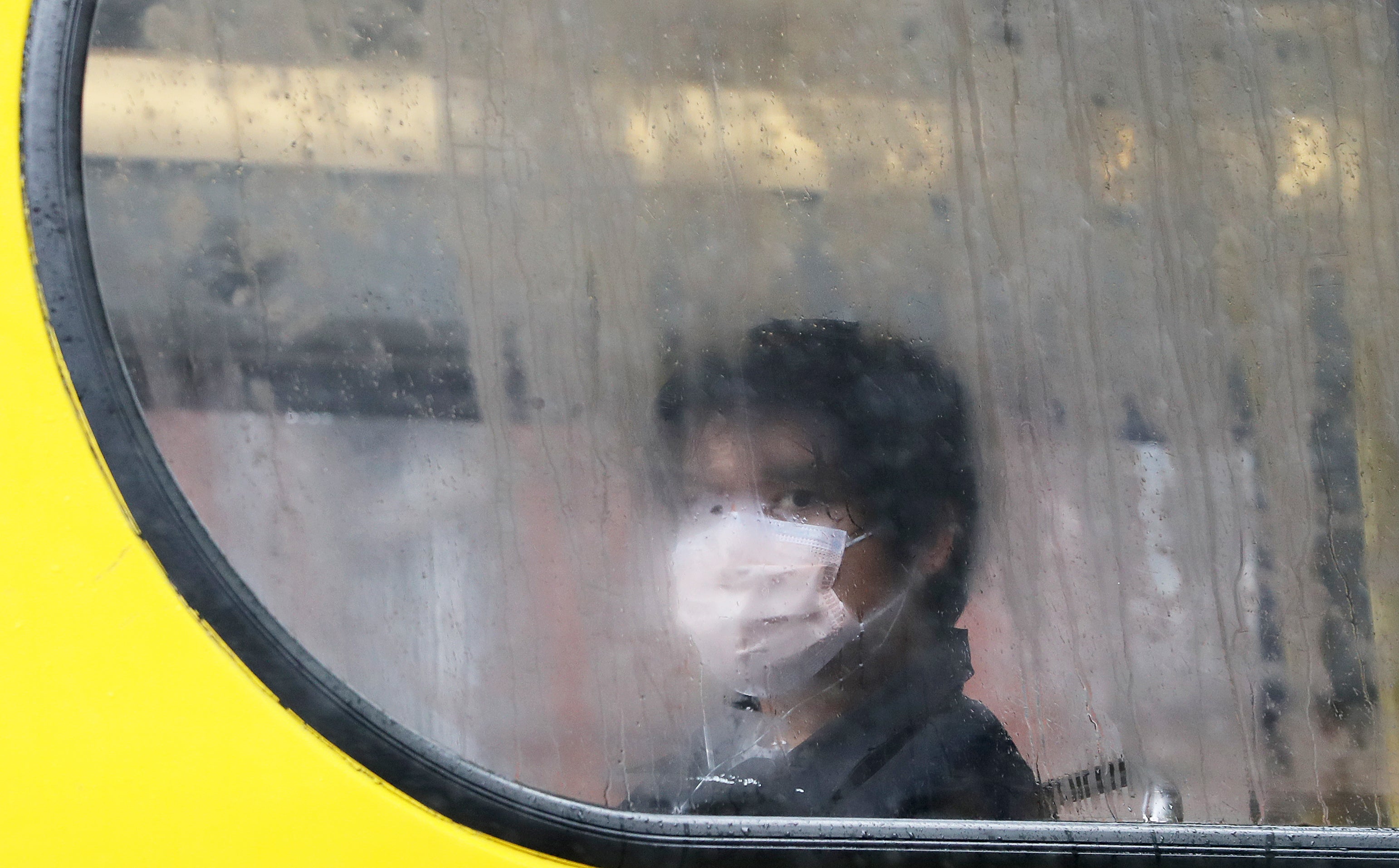 A person wearing a protective face mask sits on a bus in Dublin (Brian Lawless/PA)