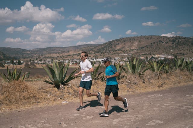 <p>Kevin Sieff (left) and Germán Silva run along a dirt road in Tlaxcala</p>