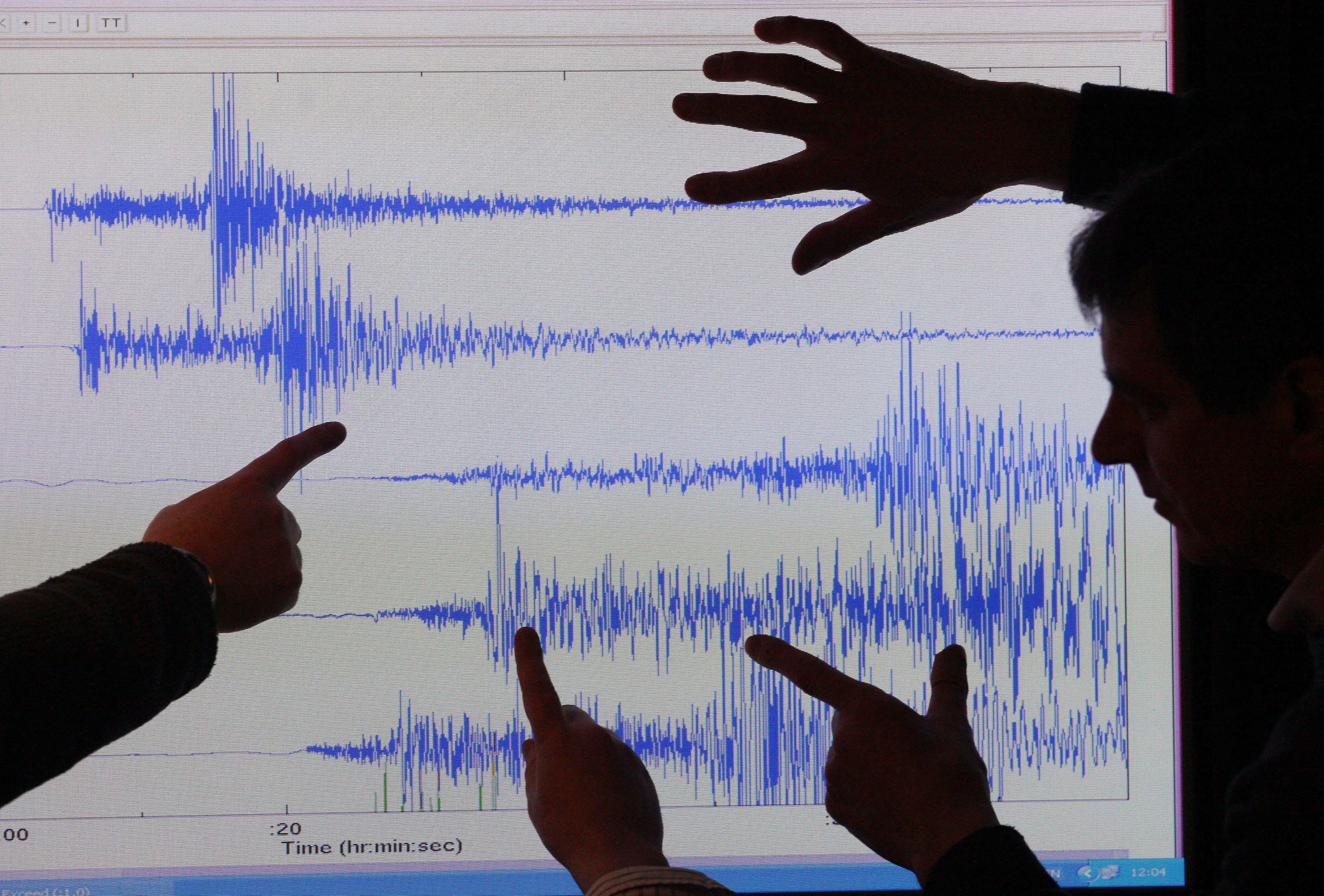 Staff at the British Geological Survey, Edinburgh look at a graph showing an earthquake (David Cheskin/PA)
