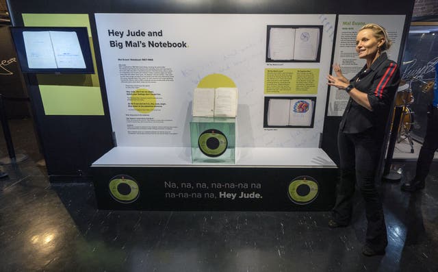 Davinia Taylor next to the personal notebook belonging to The Beatles’ tour manager, Mal Evans, now on display at the Beatles Story in Liverpool (Peter Byrne/PA)