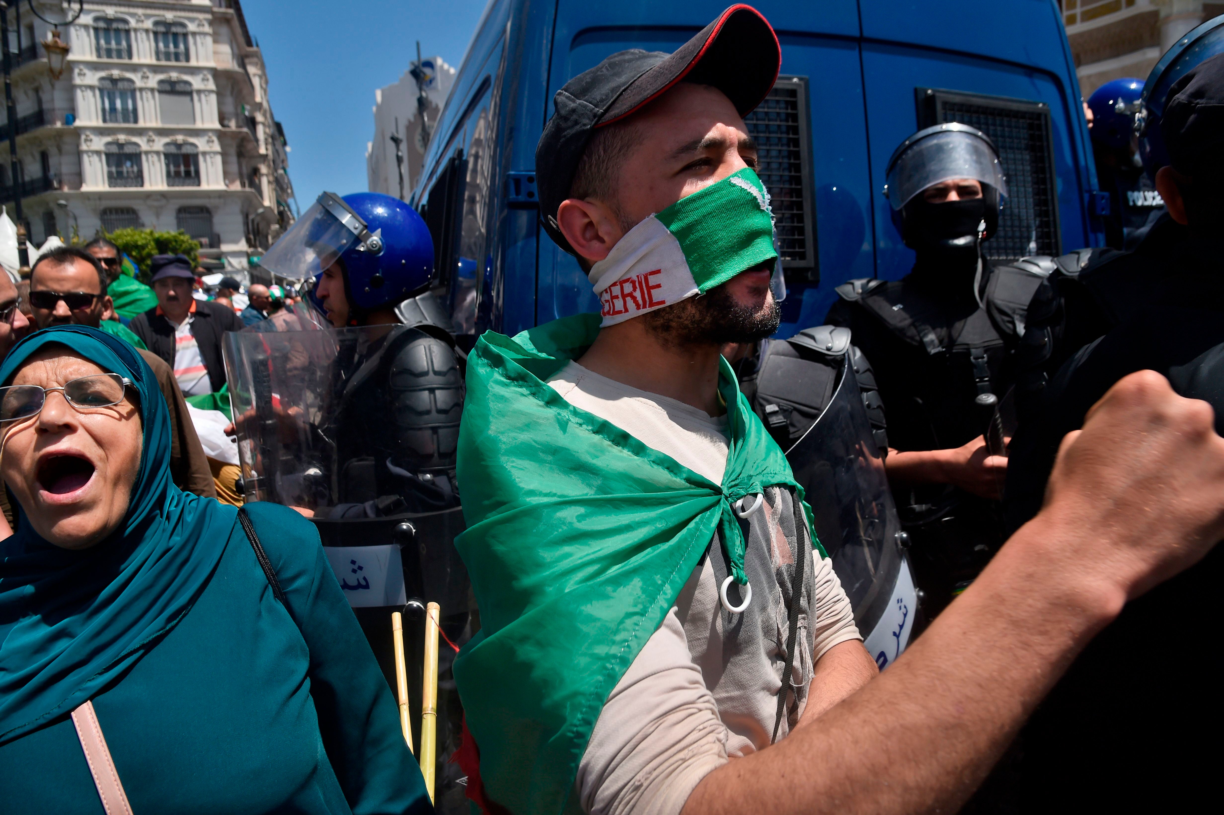 File photo: Algerian protesters draped in national flags chant slogans outside the central post office during an anti-government demonstration in the capital Algiers, 17 May 2019