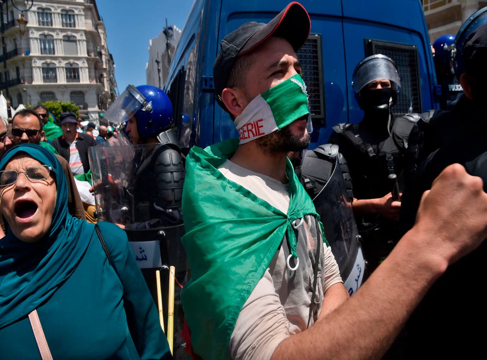 <p>File photo: Algerian protesters draped in national flags chant slogans outside the central post office during an anti-government demonstration in the capital Algiers, 17 May 2019</p>
