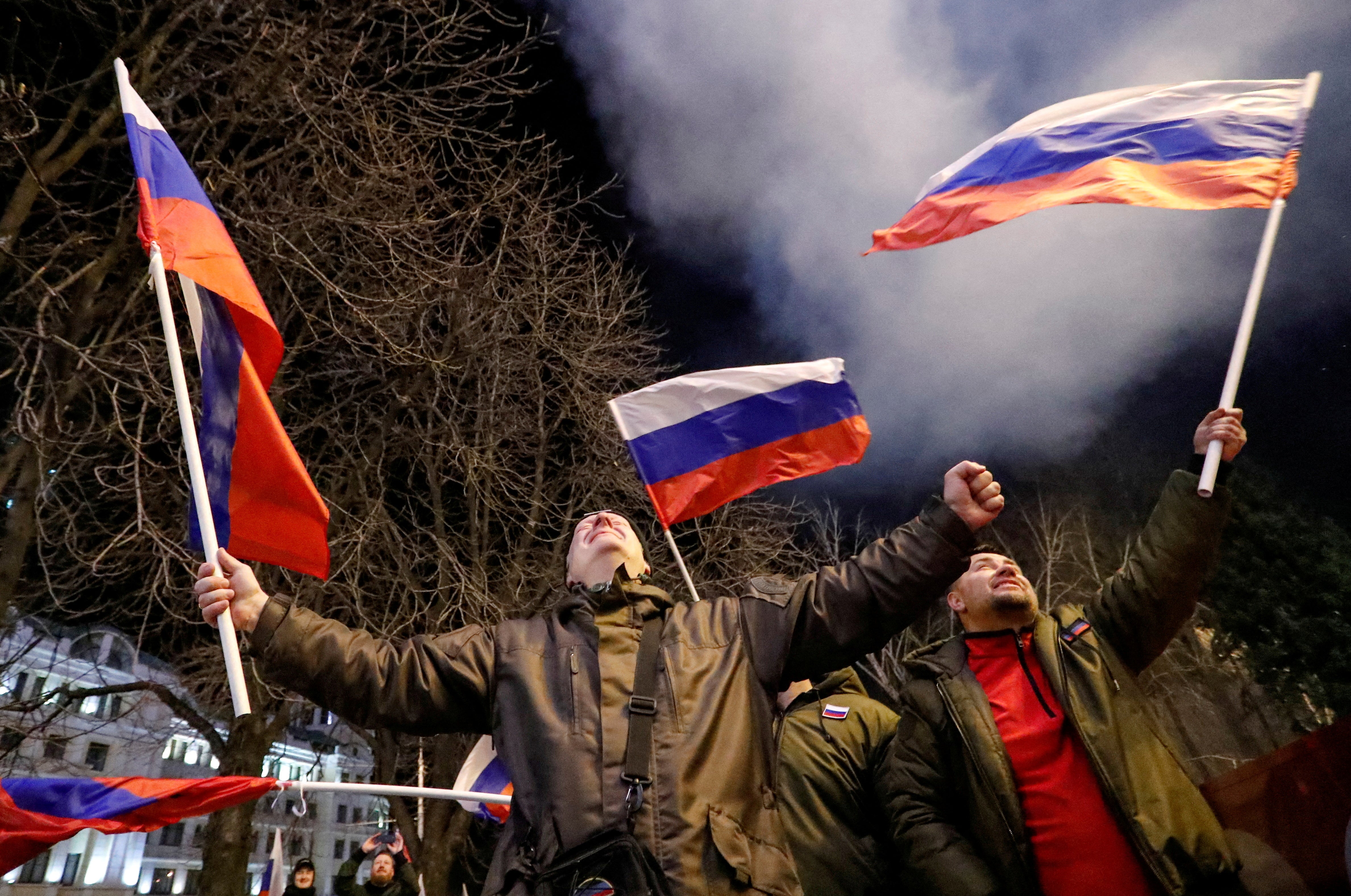 Pro-Russian activists ccelebrate after Vladimir Putin signed a decree recognising two Russian-backed breakaway regions in eastern Ukraine