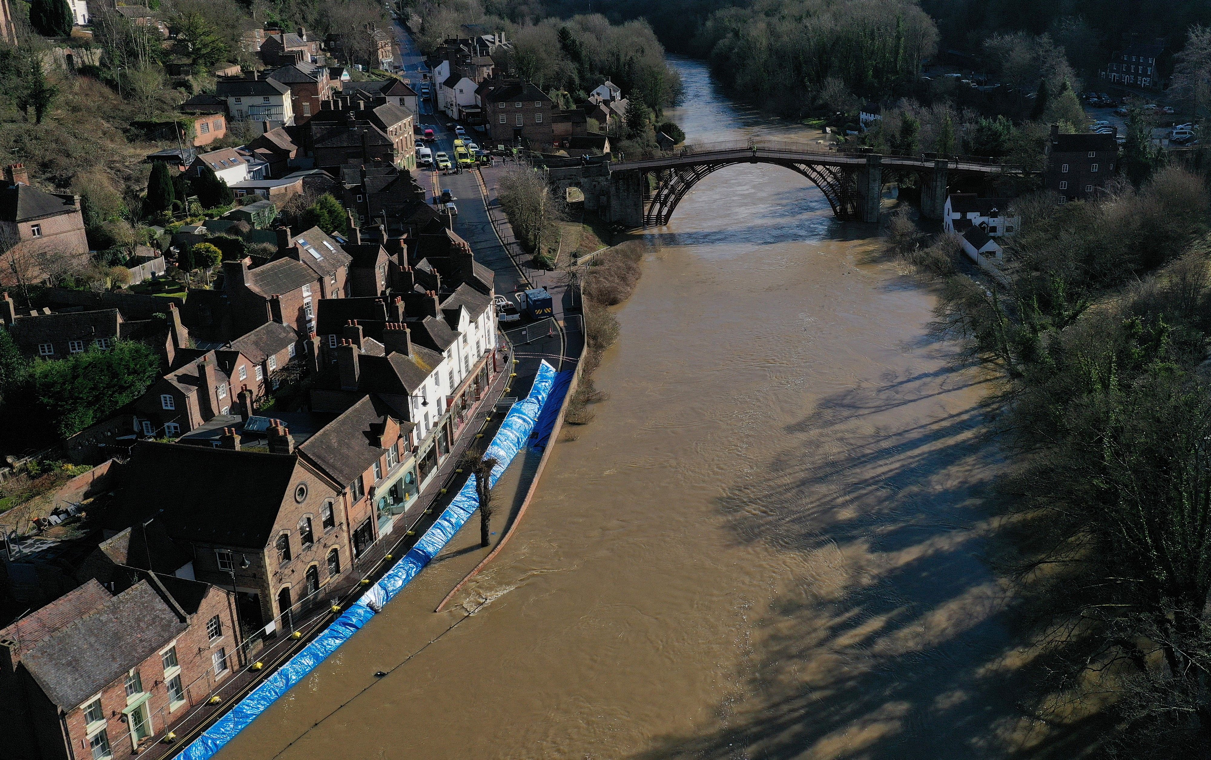 An aerial view shows temporary flood defences, put in place by the Environment Agency to protect homes and businesses, along the burst banks of the River Severn after the river burst its banks in Ironbridge, central England, on 22 February 2022