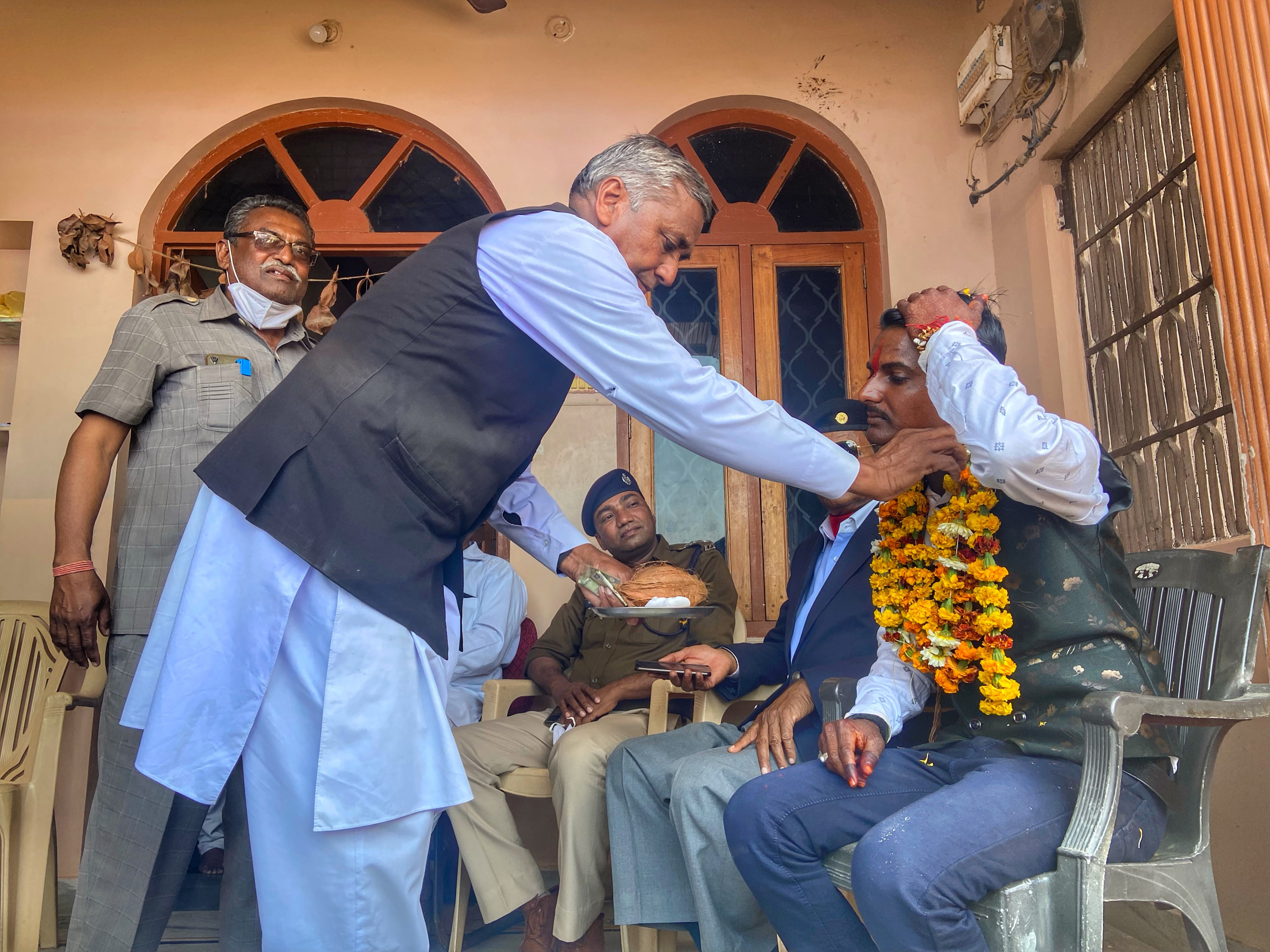 Former village headman Ram Prasad, from an upper caste, greets Bairwa at his house