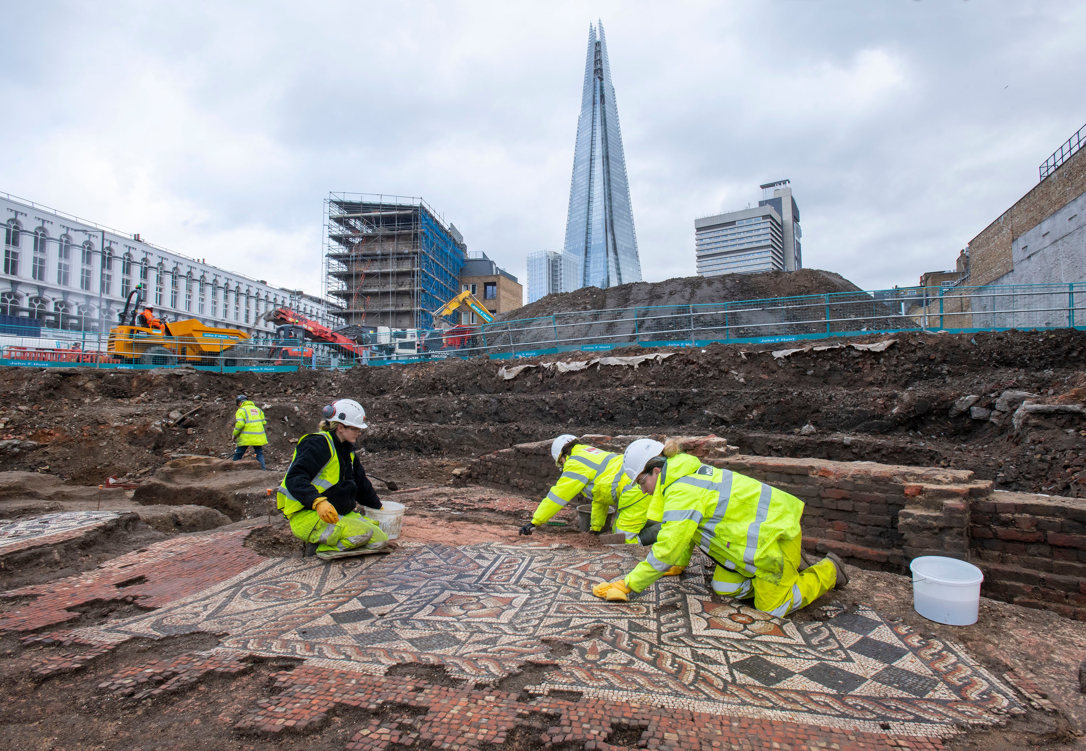 MOLA archaeologists at work on the mosaic unearthed in Southwark