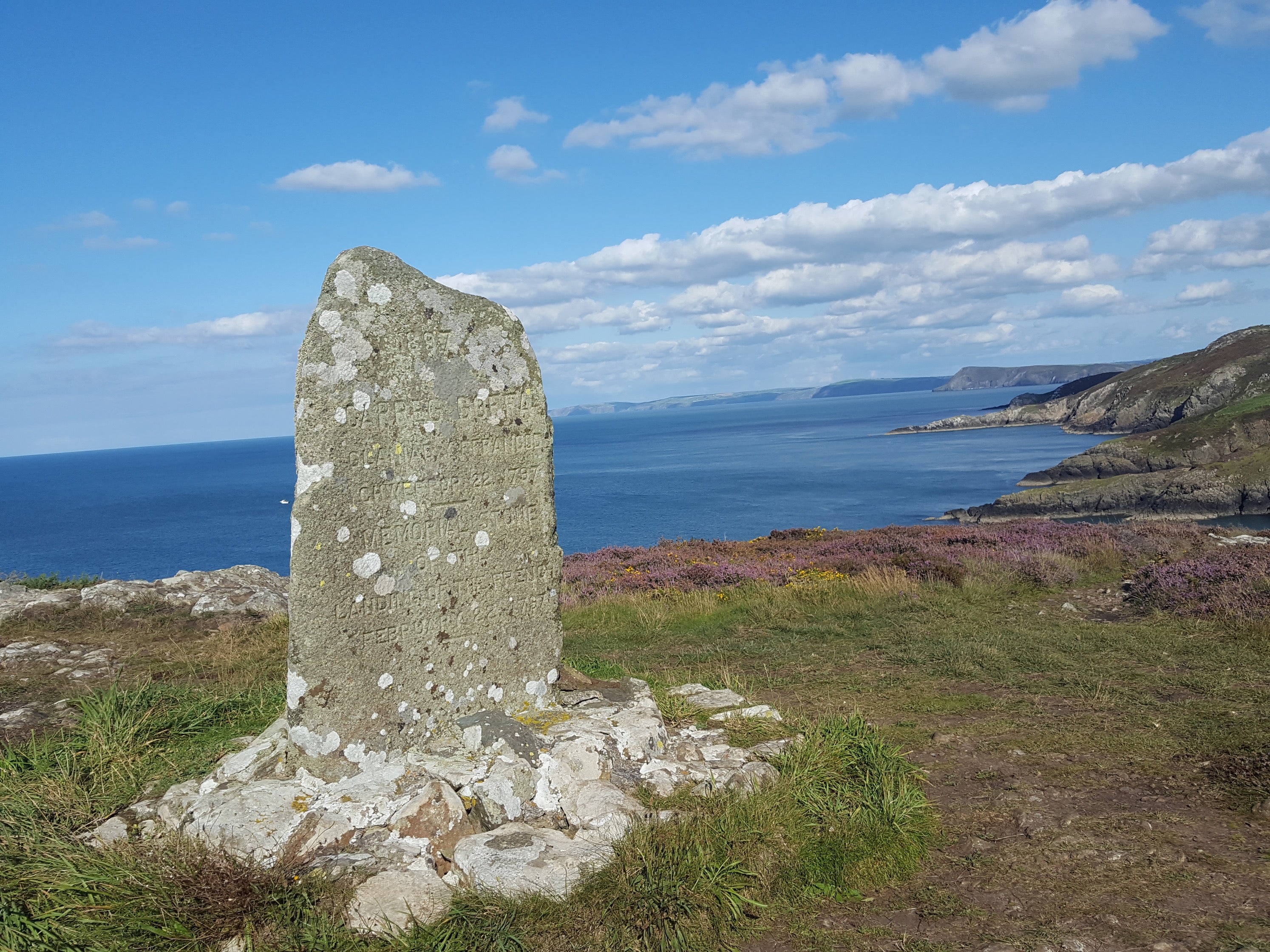 A memorial stone on the cliff above the landing site, with Welsh and English inscription