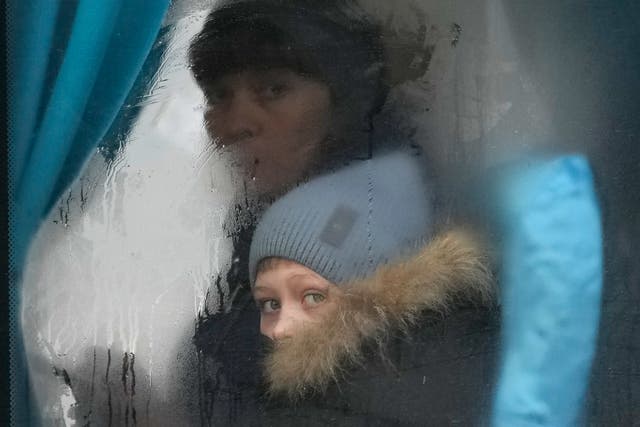 <p>A woman and child peer out of the window of a bus as they leave Sievierodonetsk, in eastern Ukraine, on Thursday</p>