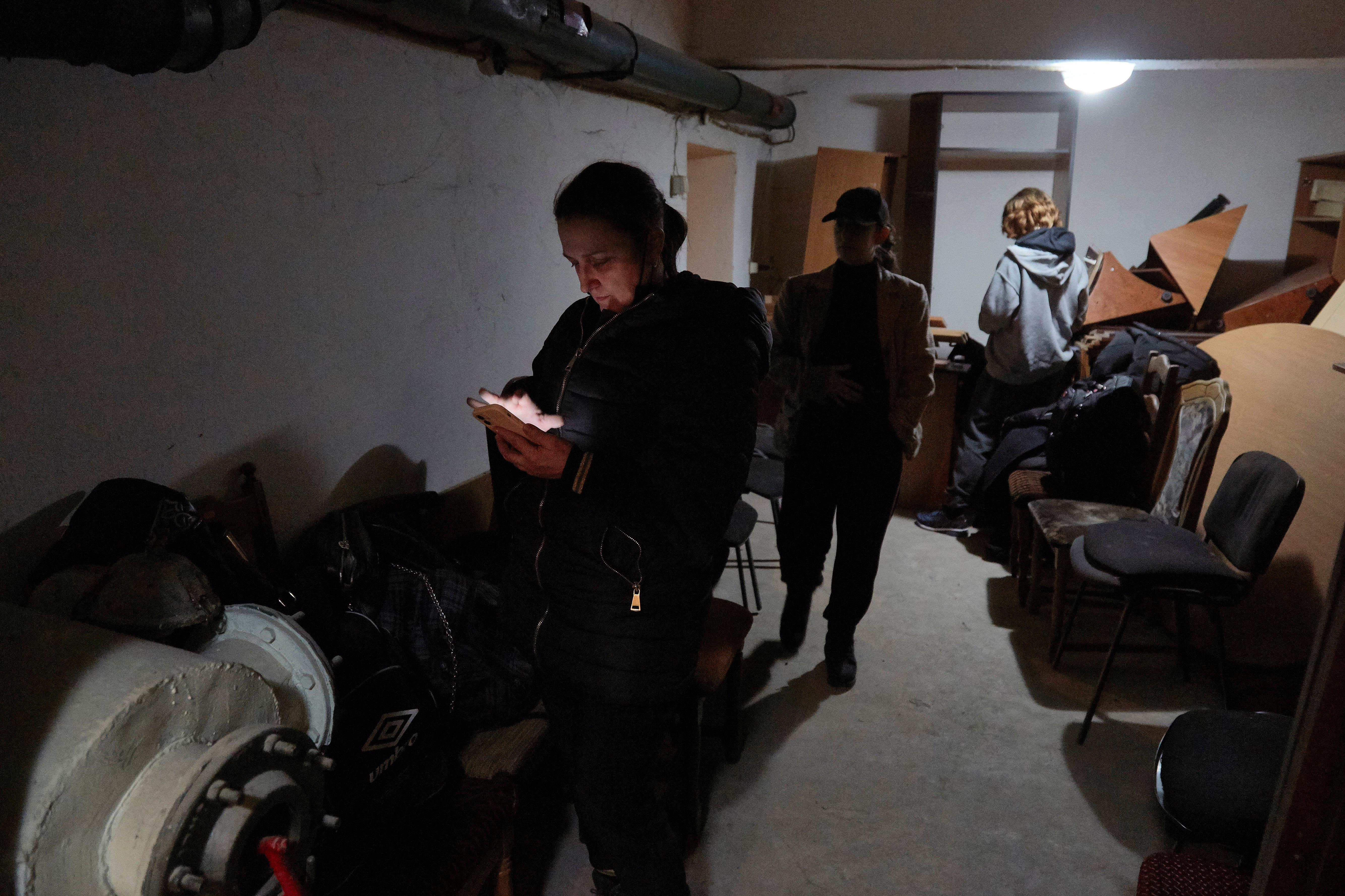 Local residents follow the news on their mobile devices in a bomb shelter on 24 February 2022 in Kyiv, Ukraine