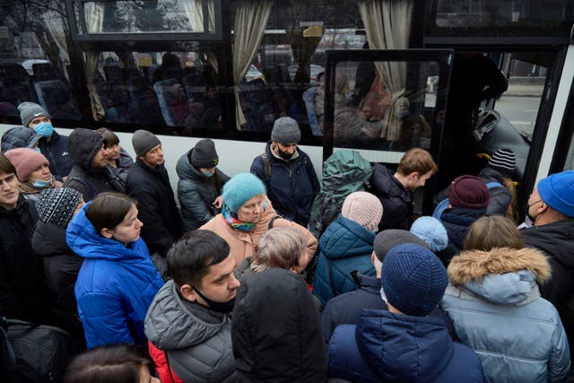 <p>People in Kiev board a bus as they attempt to evacuate the city following Russia’s invasion </p>