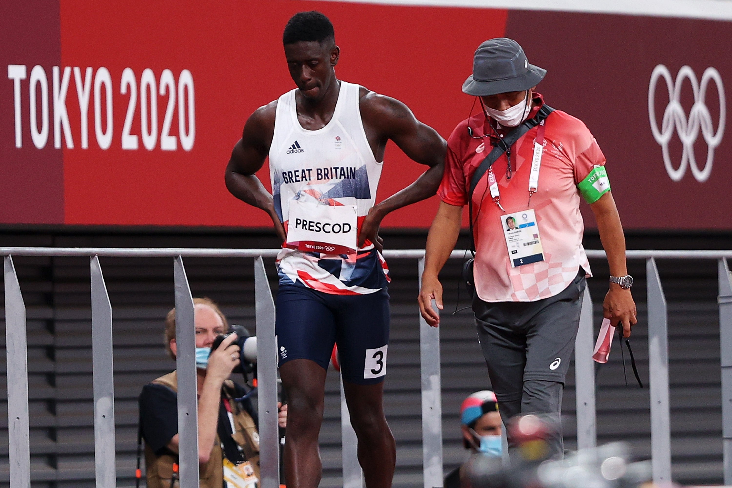Prescod is accompanied from the track after his false start in Tokyo