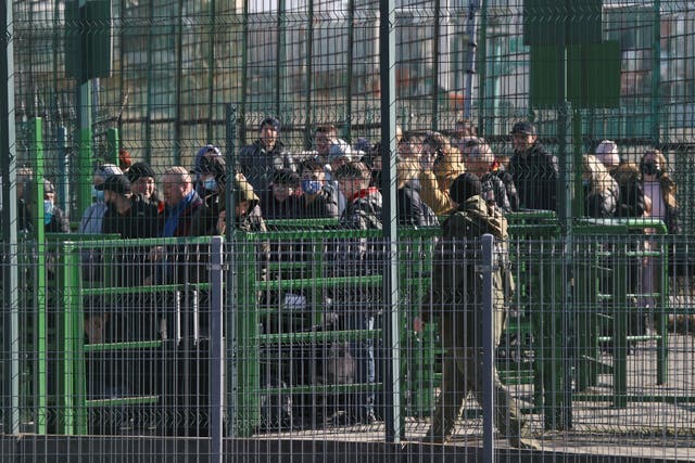 <p>People wait at the Ukrainian side of the border crossing between Medyka, Poland and Ukraine. </p>