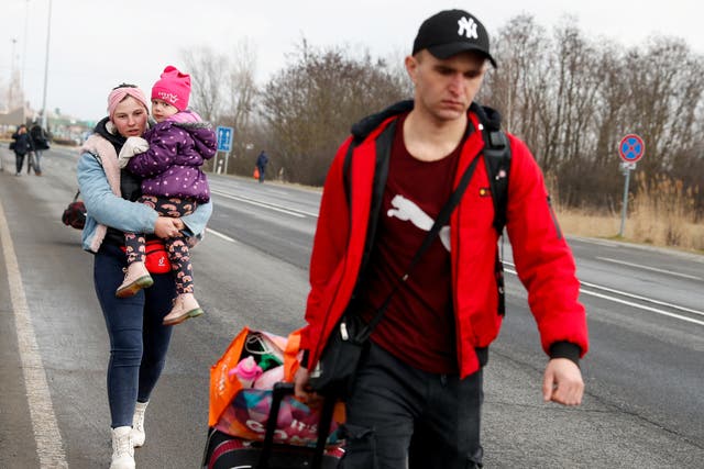 <p>People flee from Ukraine at the Hungarian-Ukrainian border on Thursday </p>