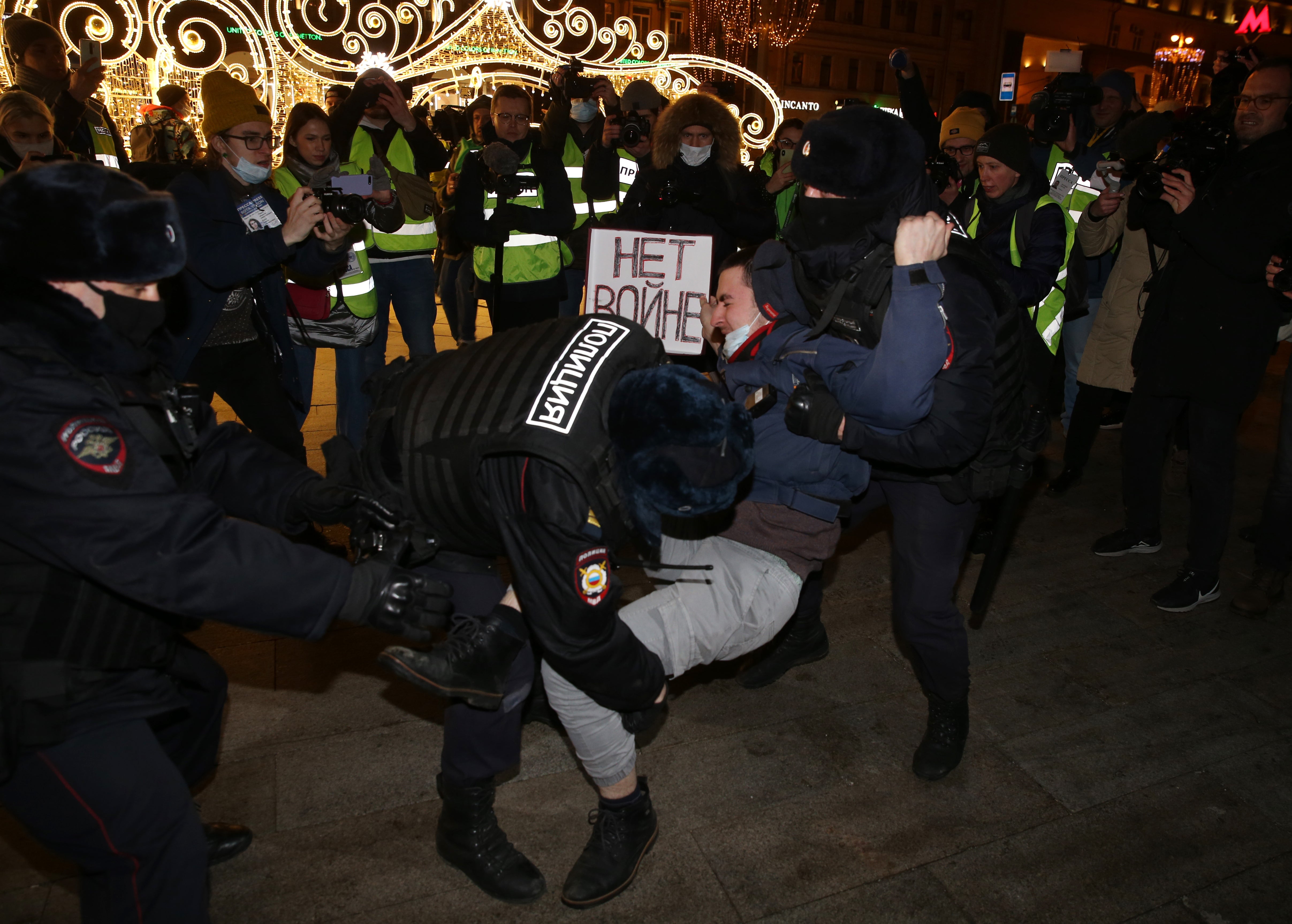 Police officers detain a man holding a placard reading “No war” during a protest at Pushkinskaya Square, in Moscow