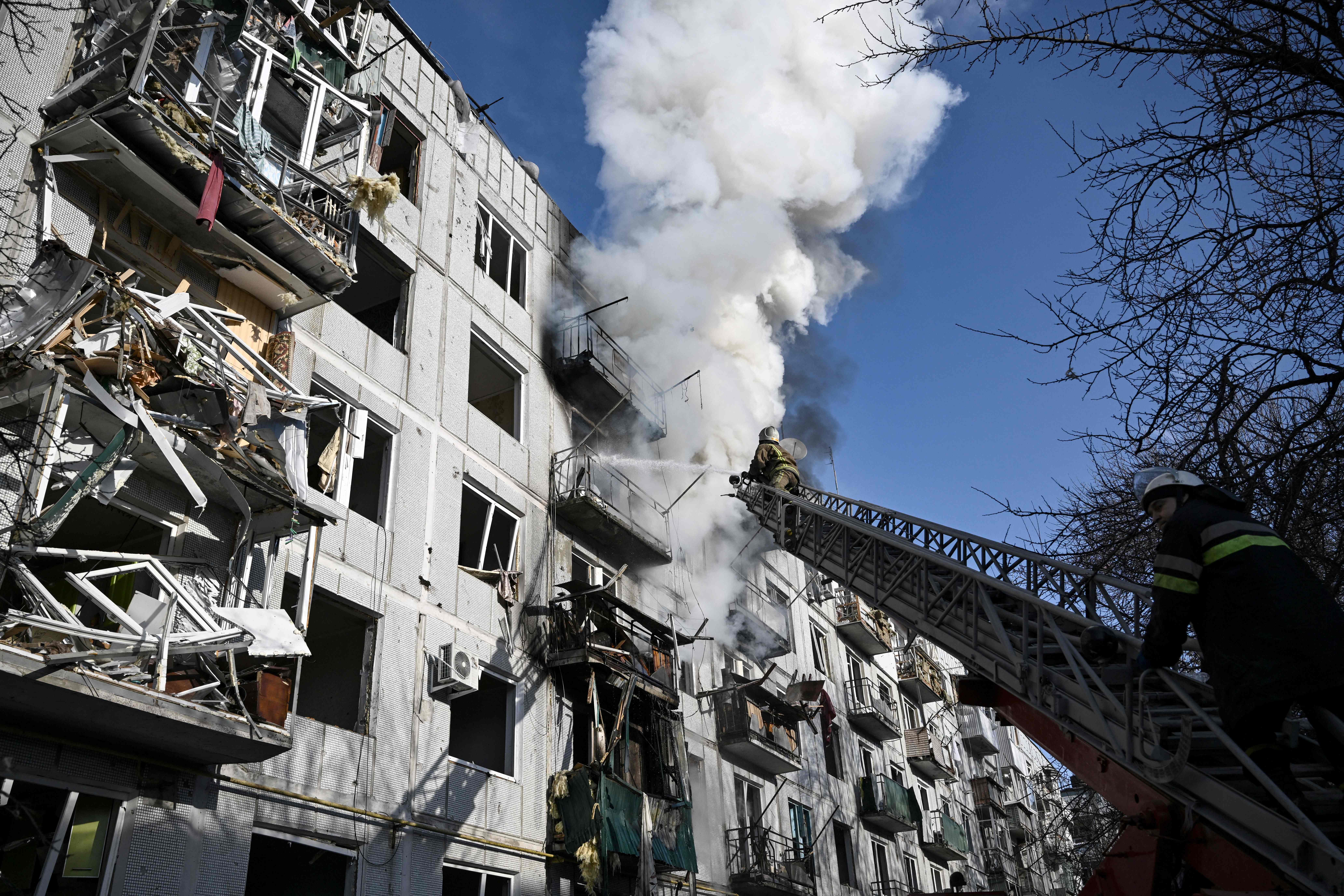 Firefighters attend to a building in Chuguiv, near Kharkiv, on Thursday