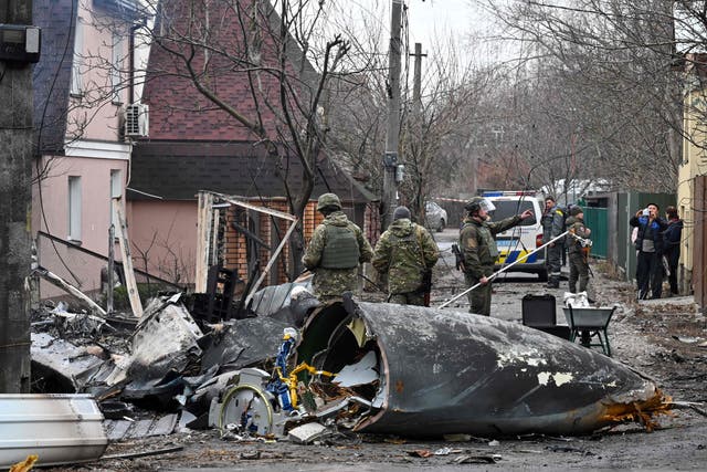 <p>Ukrainian servicemen work by the wreckage of an unidentified aircraft which crashed into a private house in a residential area in Kiev on 25 February </p>