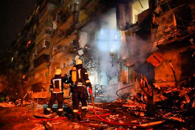 <p>Firefighters inspect damage following a rocket attack on Kyiv</p>