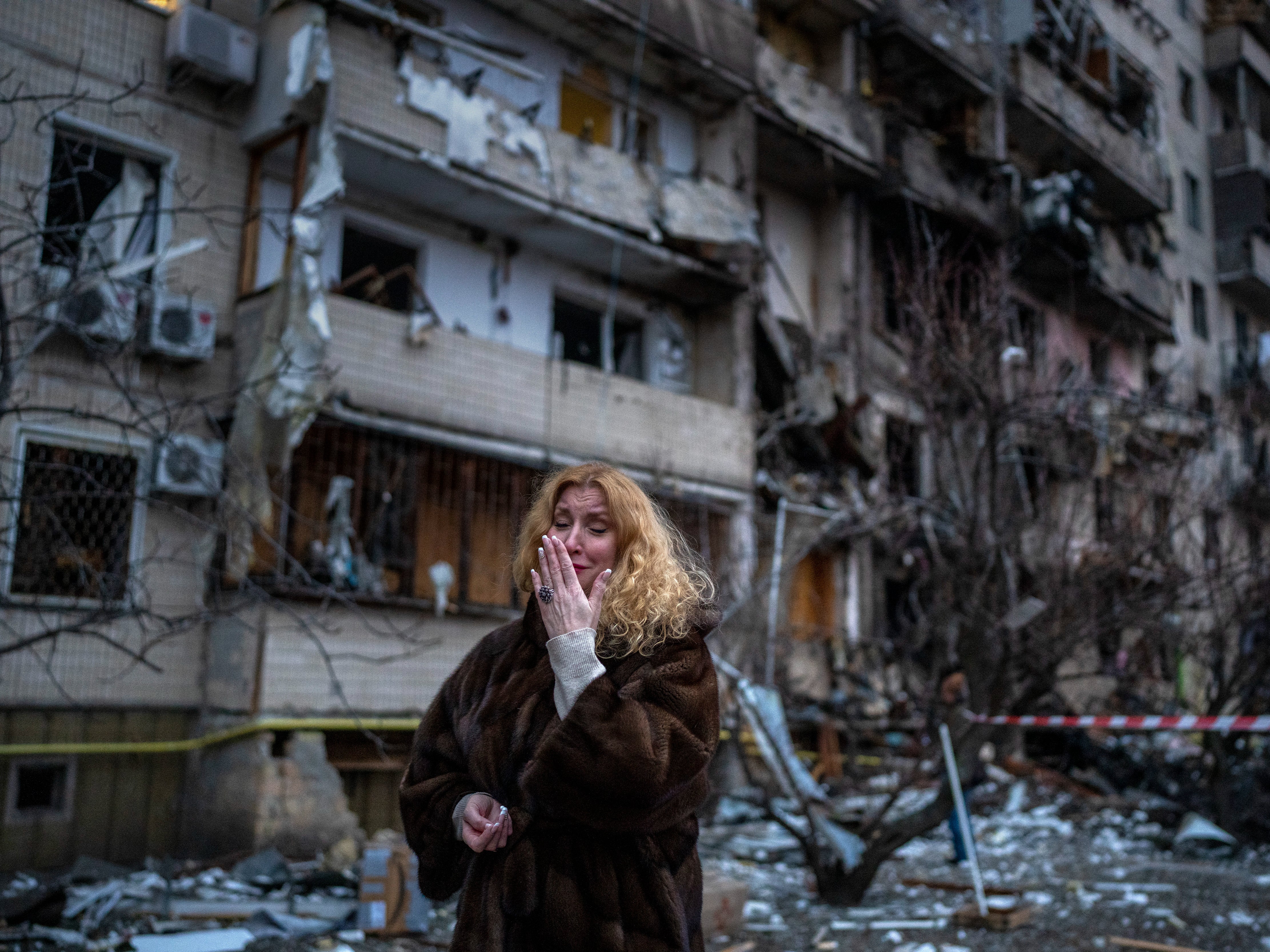 Natali Sevriukova reacts next to her house following a rocket attack the city of Kyiv