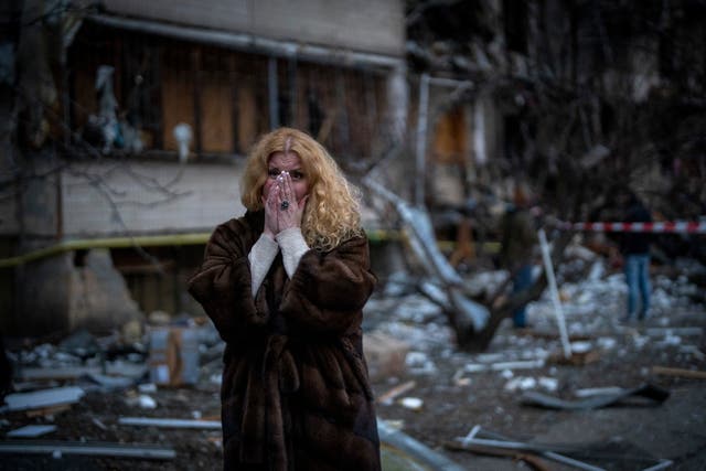 <p>Natali Sevriukova stands next to her house following a rocket attack in Kyiv on Friday </p>