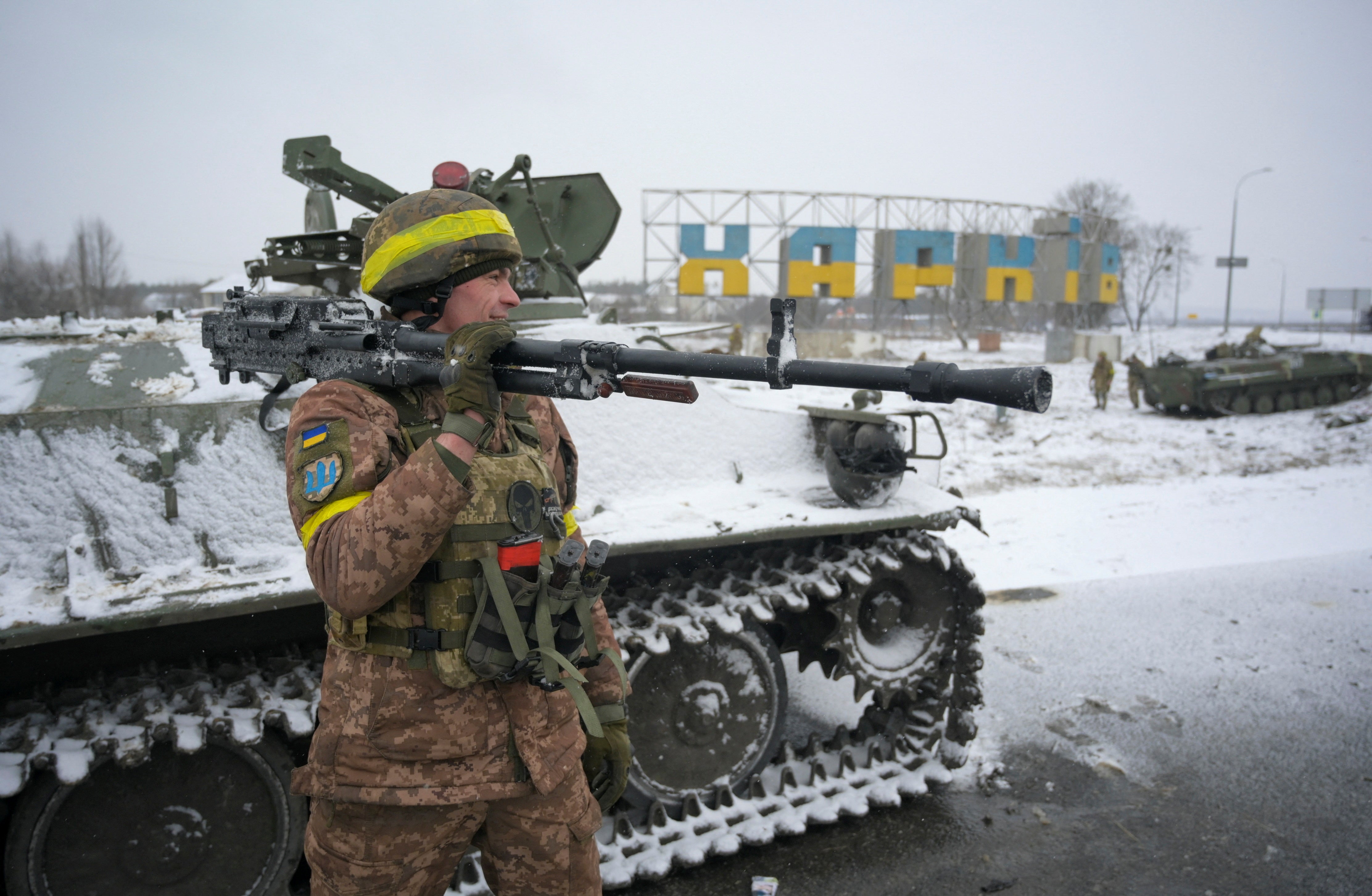 A Ukrainian serviceman reacts while holding a weapon in Kharkiv, Ukraine