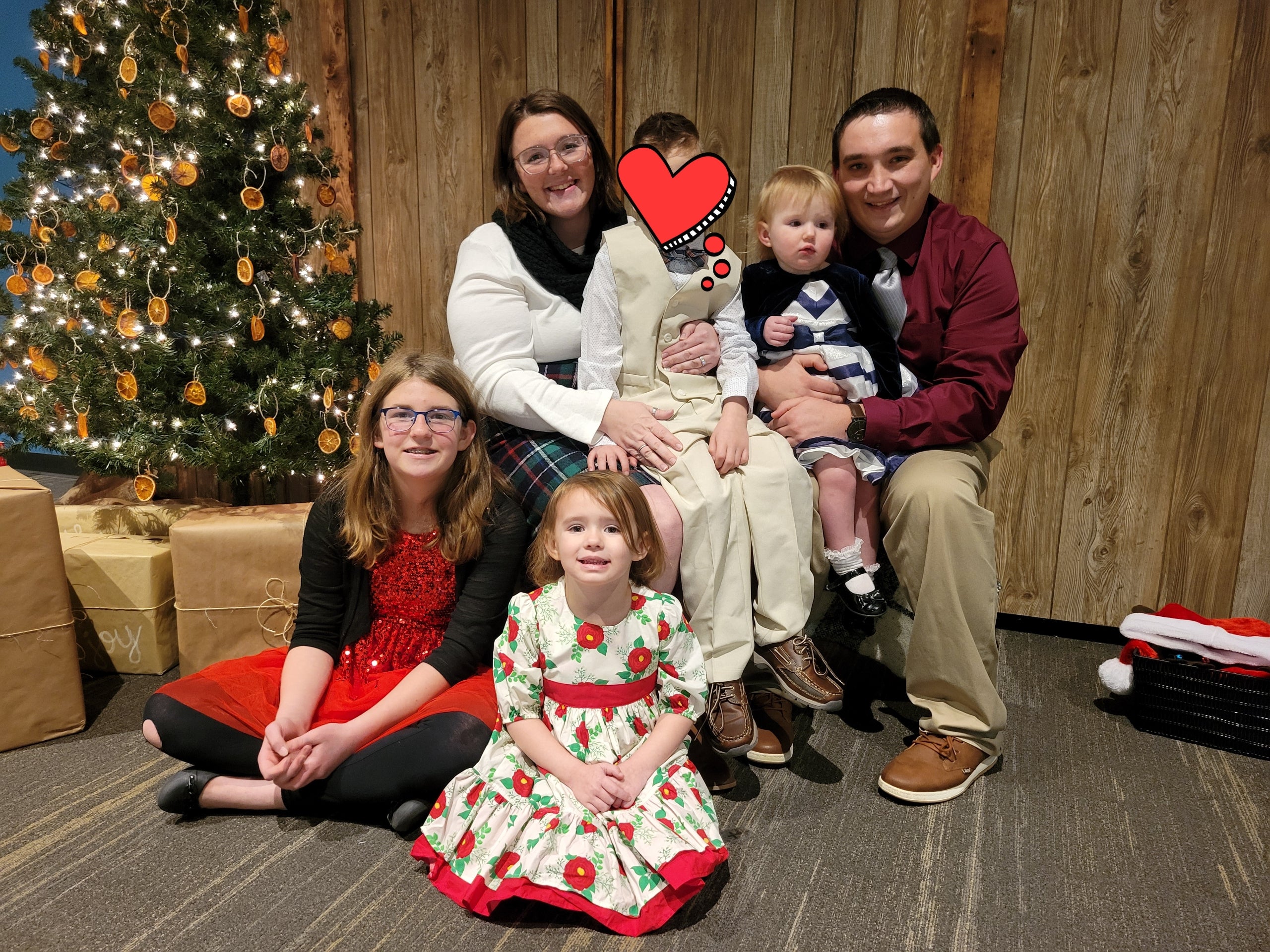 Anthony and Shannon Estes, of Plainfield, IL, pose with their children and the 7-year-old Ukrainian orphan they hosted over the winter; they are shielding his identity for the moment after filing his adoption application earlier this month