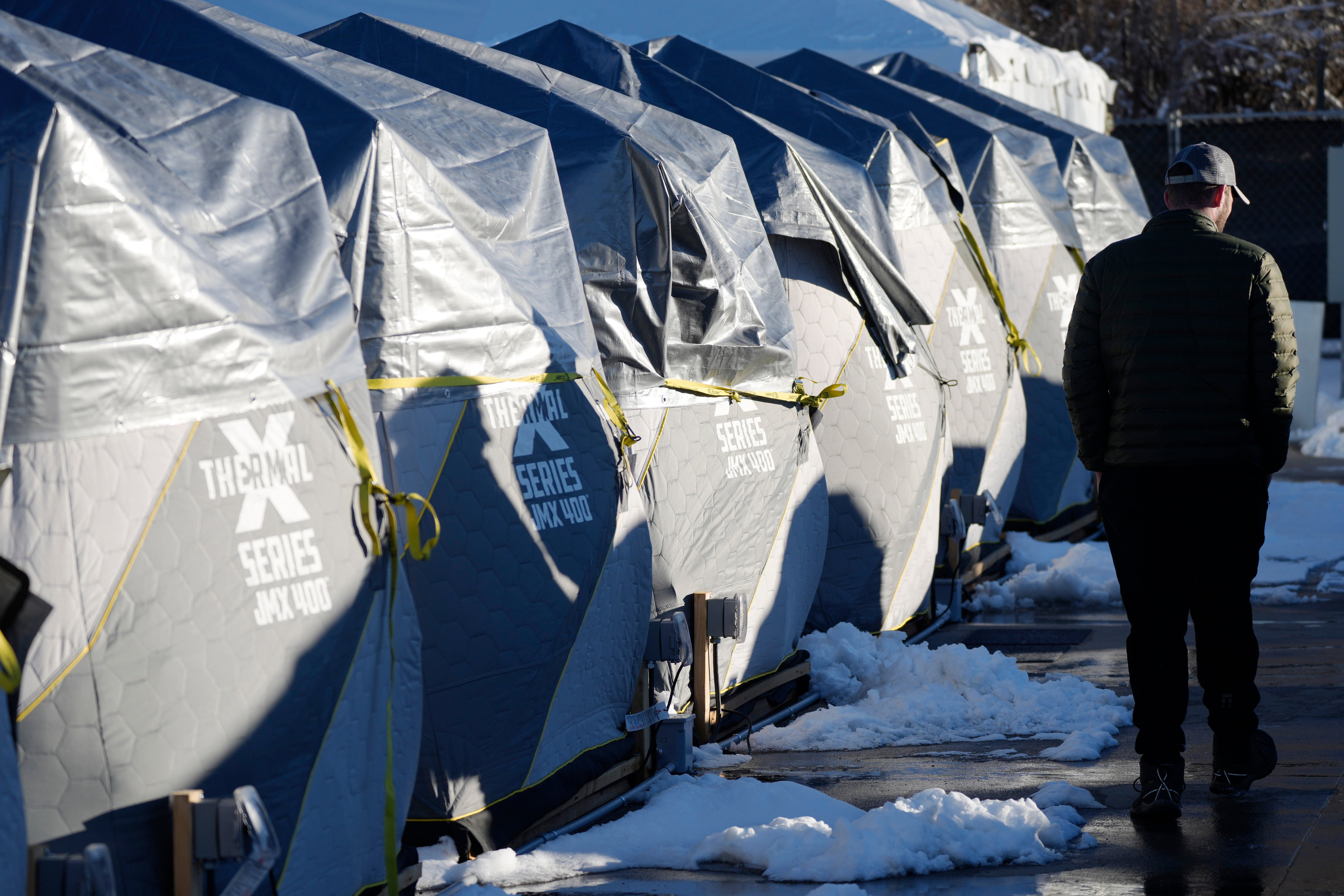 Tents stand in a long row at the east safe outdoor space in the parking lot of the city of Denver Human Service building in Denver