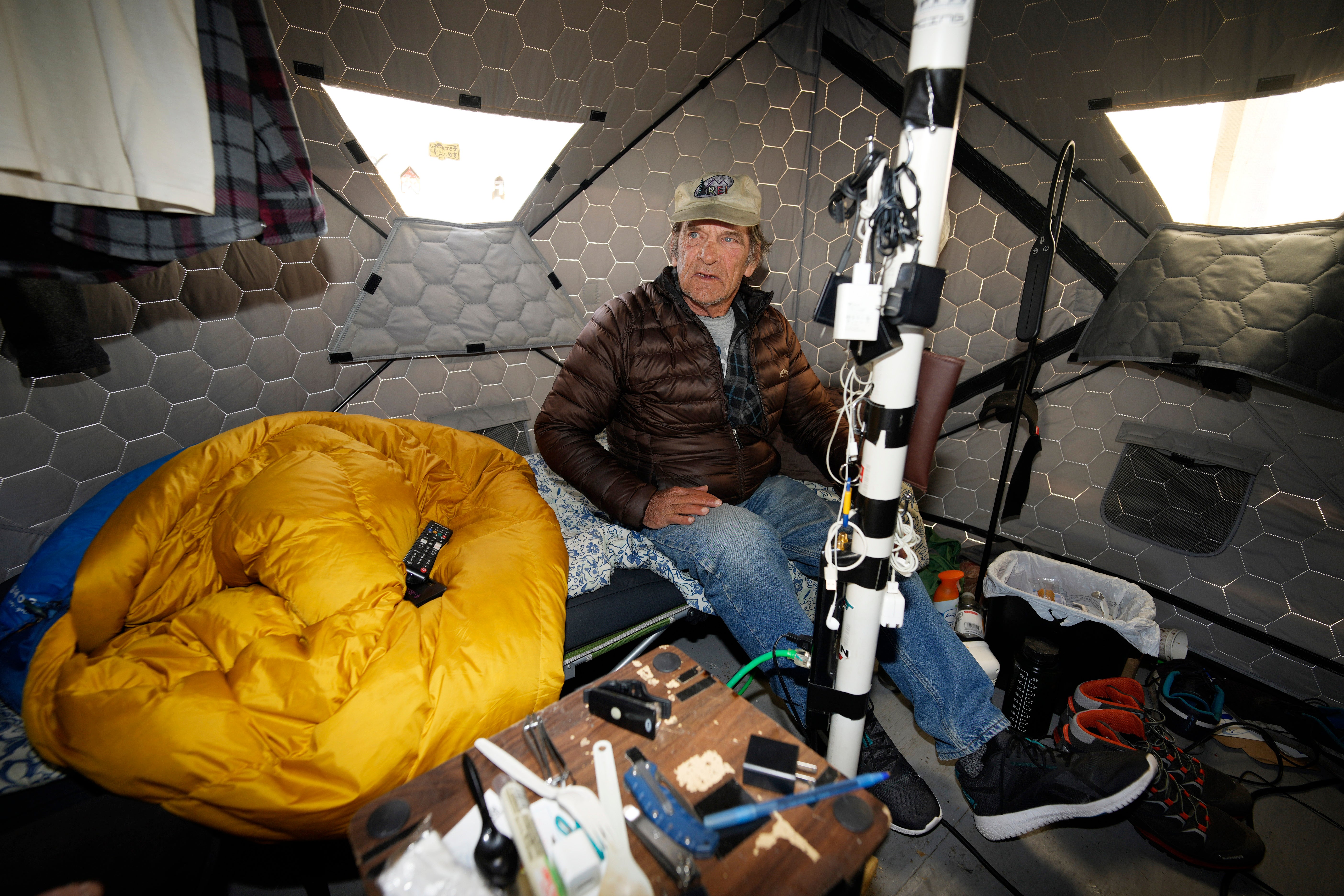 Gary Peters takes a break in his tent at the east safe outdoor space in the parking lot of the city of Denver Human Service building in Denver
