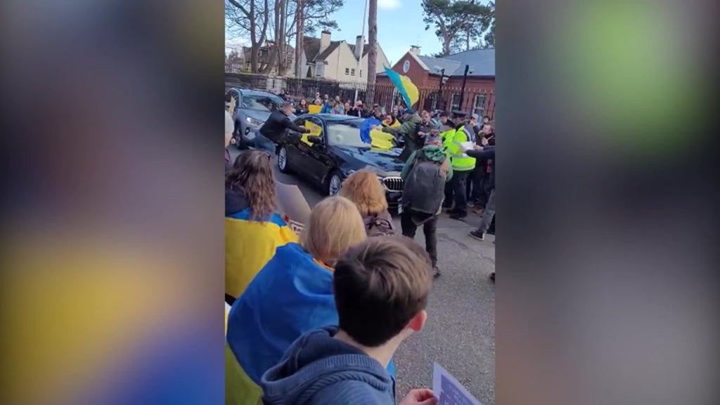 Russian ambassador’s car mobbed by angry protesters carrying Ukraine flags in Dublin