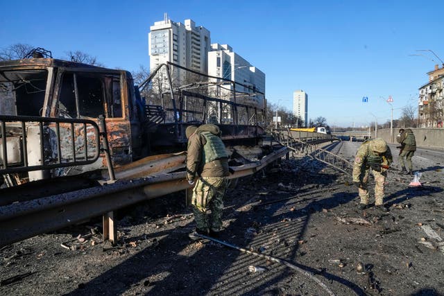 Soldados ucranianos investigan restos de un camión militar en llamas en una calle de Kiev