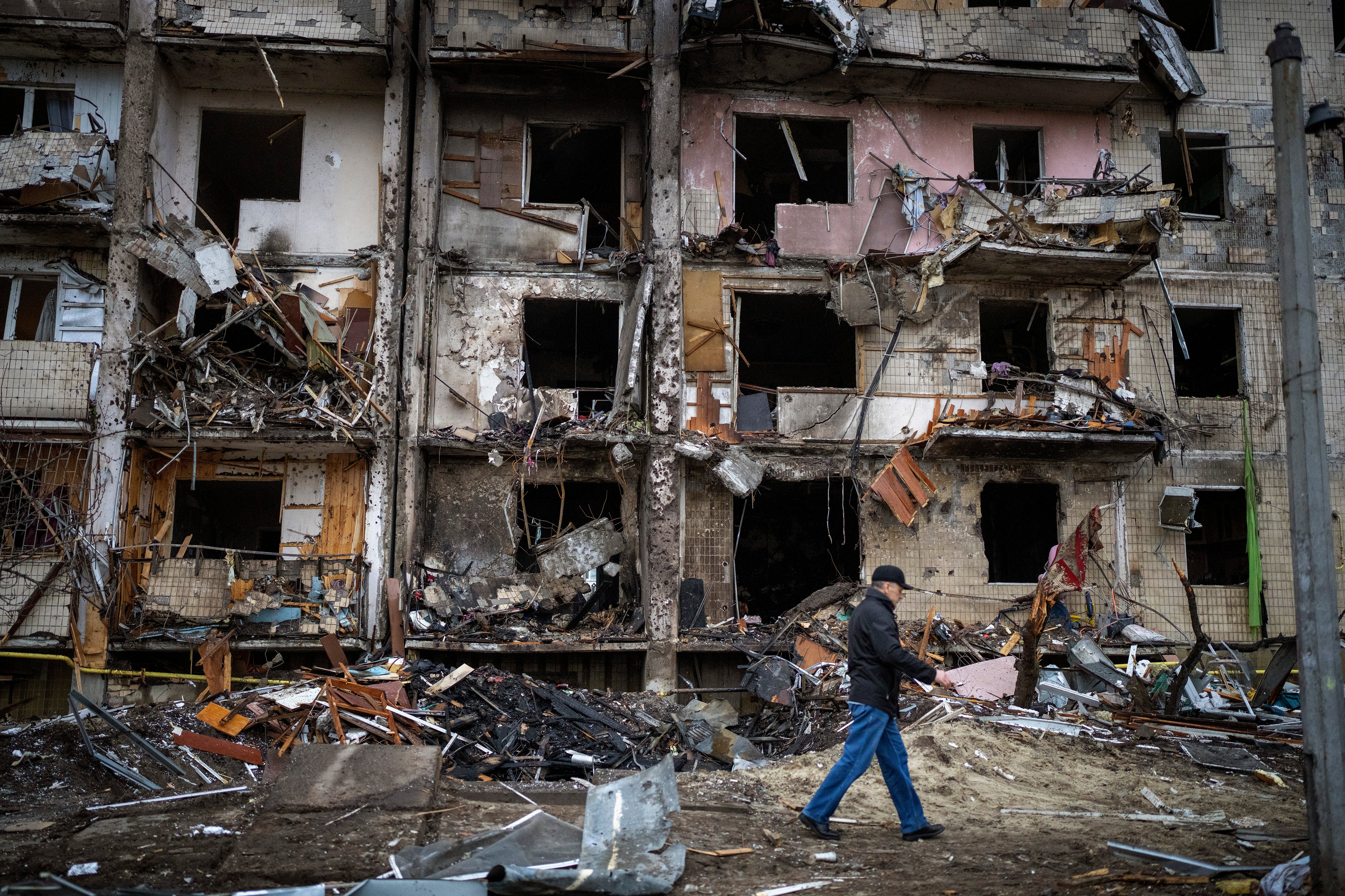 A man walks past a building damaged following a rocket attack in Kyiv