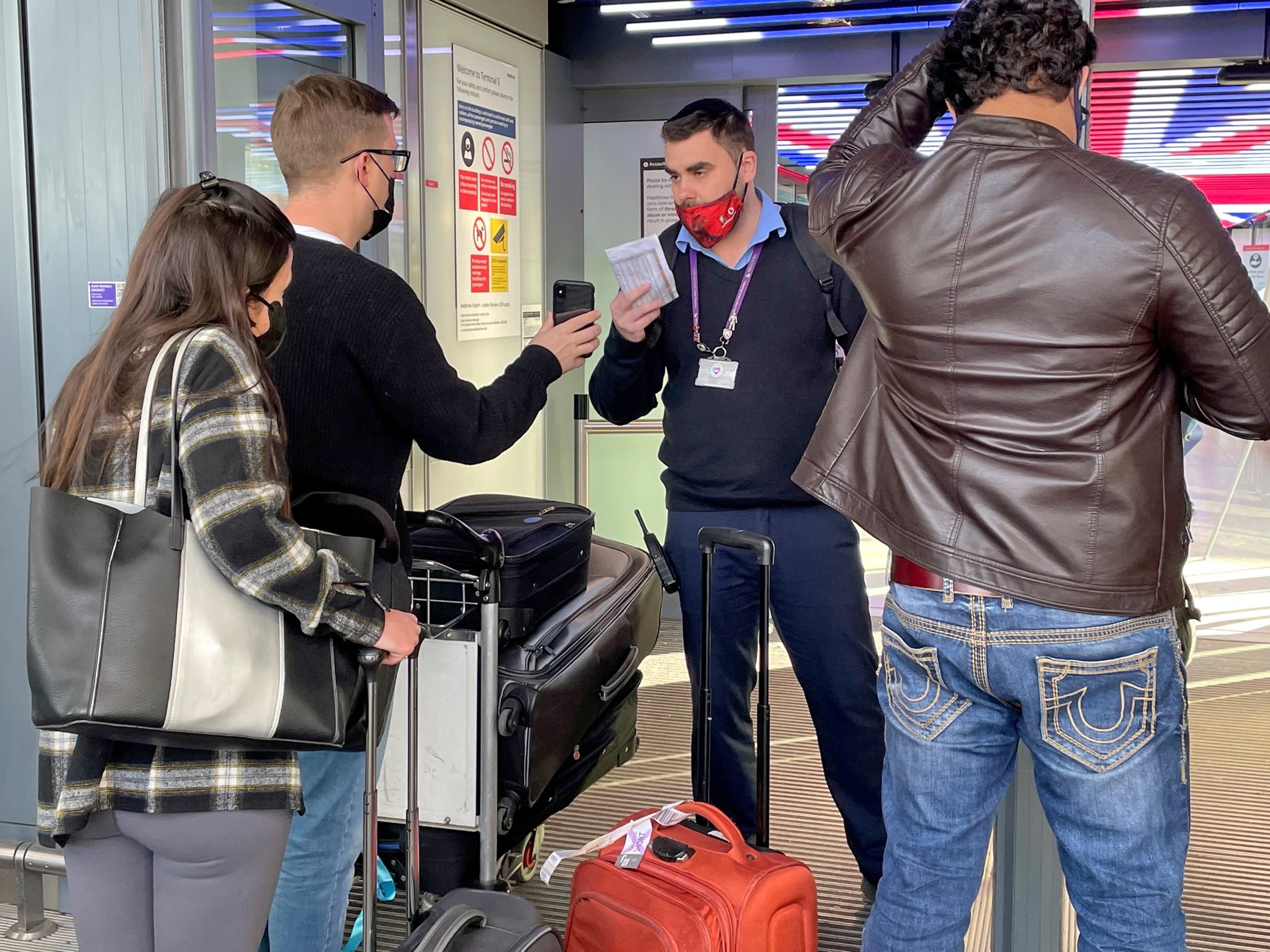 A member of staff manually checks passenger boarding passes at the entrance of Terminal 5 (Jonathan Brady/PA)
