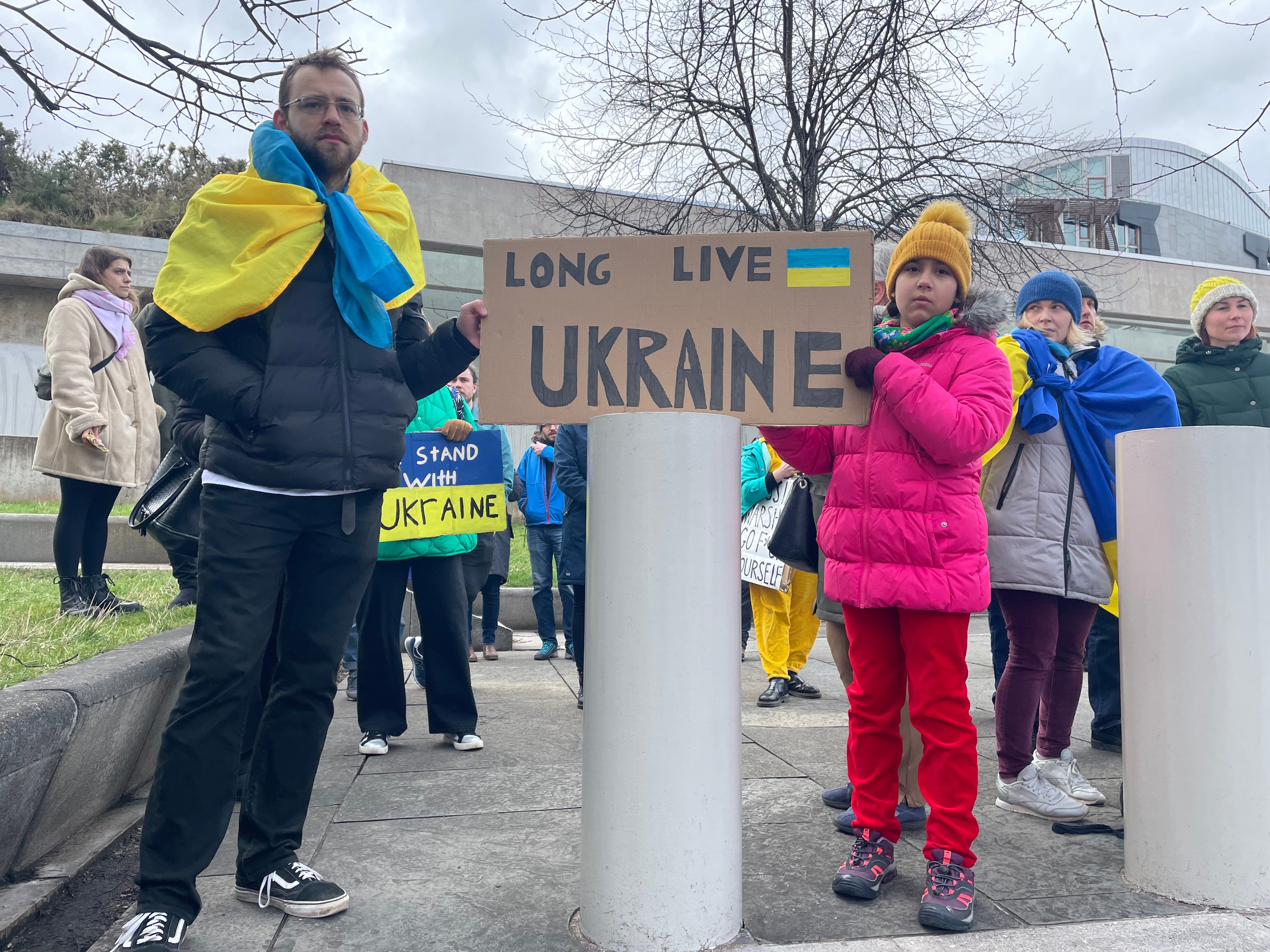 Marjan Pokhylyy, 28, standing near the Scottish Parliament building in Edinburgh, holding a sign and calling for more help to support Ukraine (Katharine Hay/PA)