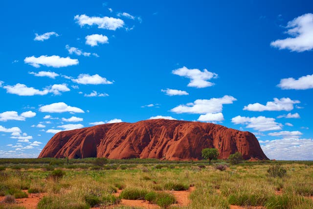 <p>Fluffy clouds drift over Uluru (also known as Ayers Rock) in the Outback</p>
