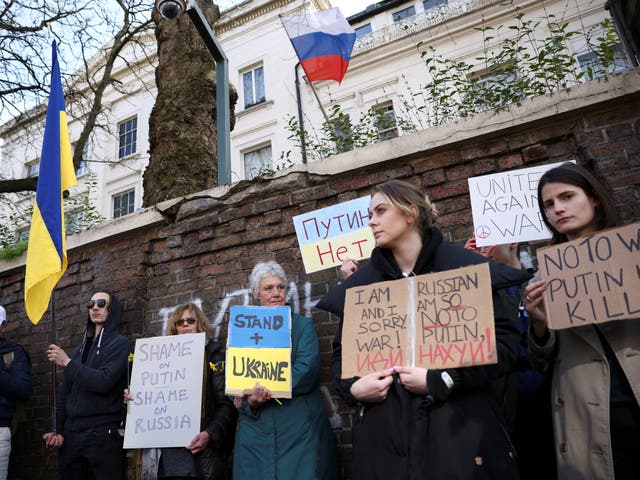 <p>Protesters hold signs during an anti-war protest outside the Russian embassy in London</p>