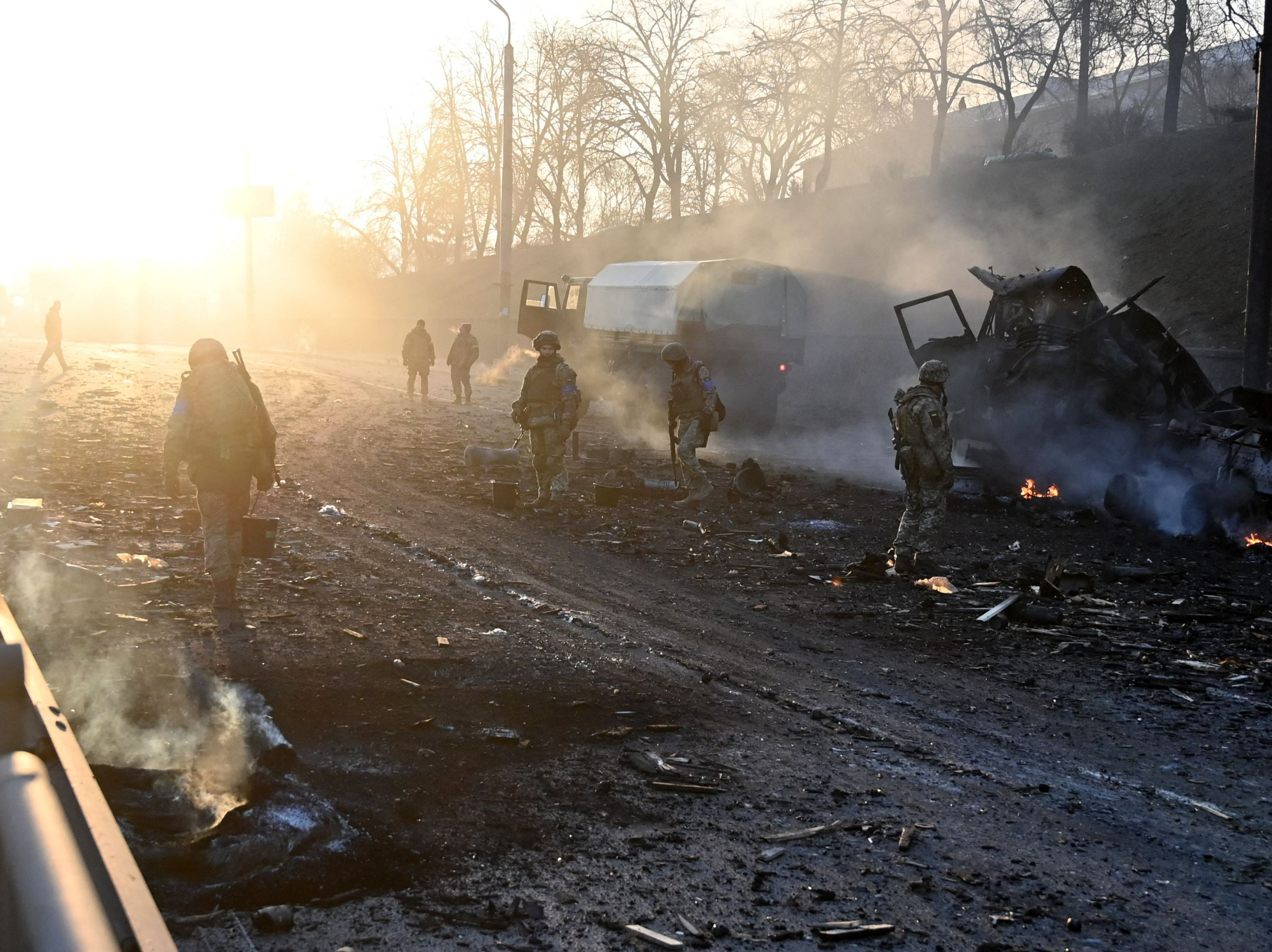 Ukrainian service members look for and collect unexploded shells after a fighting with Russian raiding group in the Ukrainian capital of Kyiv in the morning of 26 February
