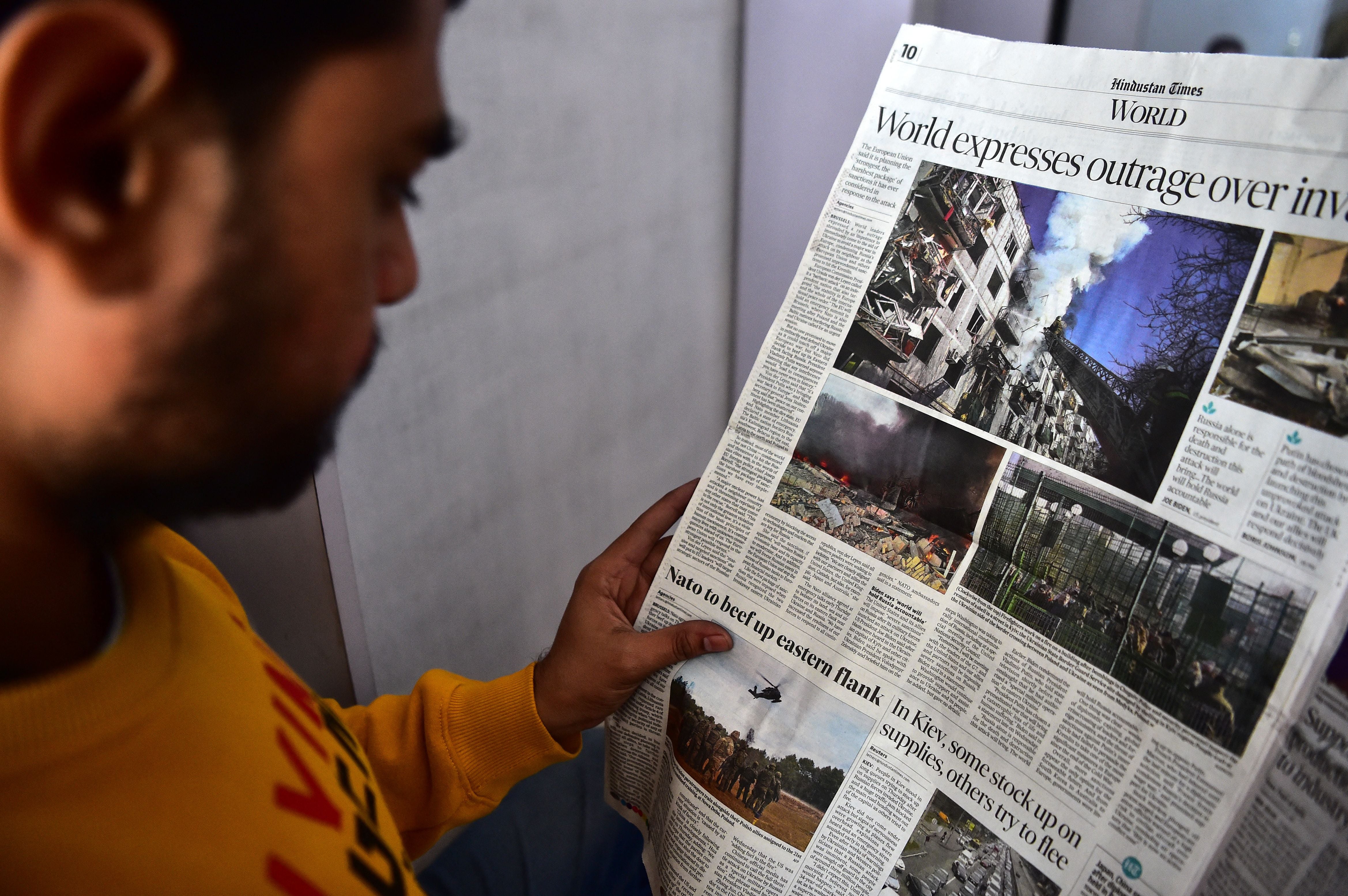 A man reads a newspaper featuring news of the Russian invasion of Ukraine, in Allahabad, India, 25 February 2022