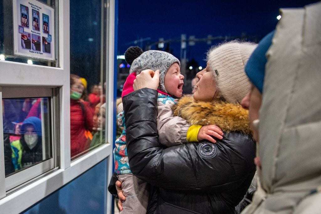 A Ukrainian woman holds a crying baby at the Slovak-Ukrainian border crossing on 25 February