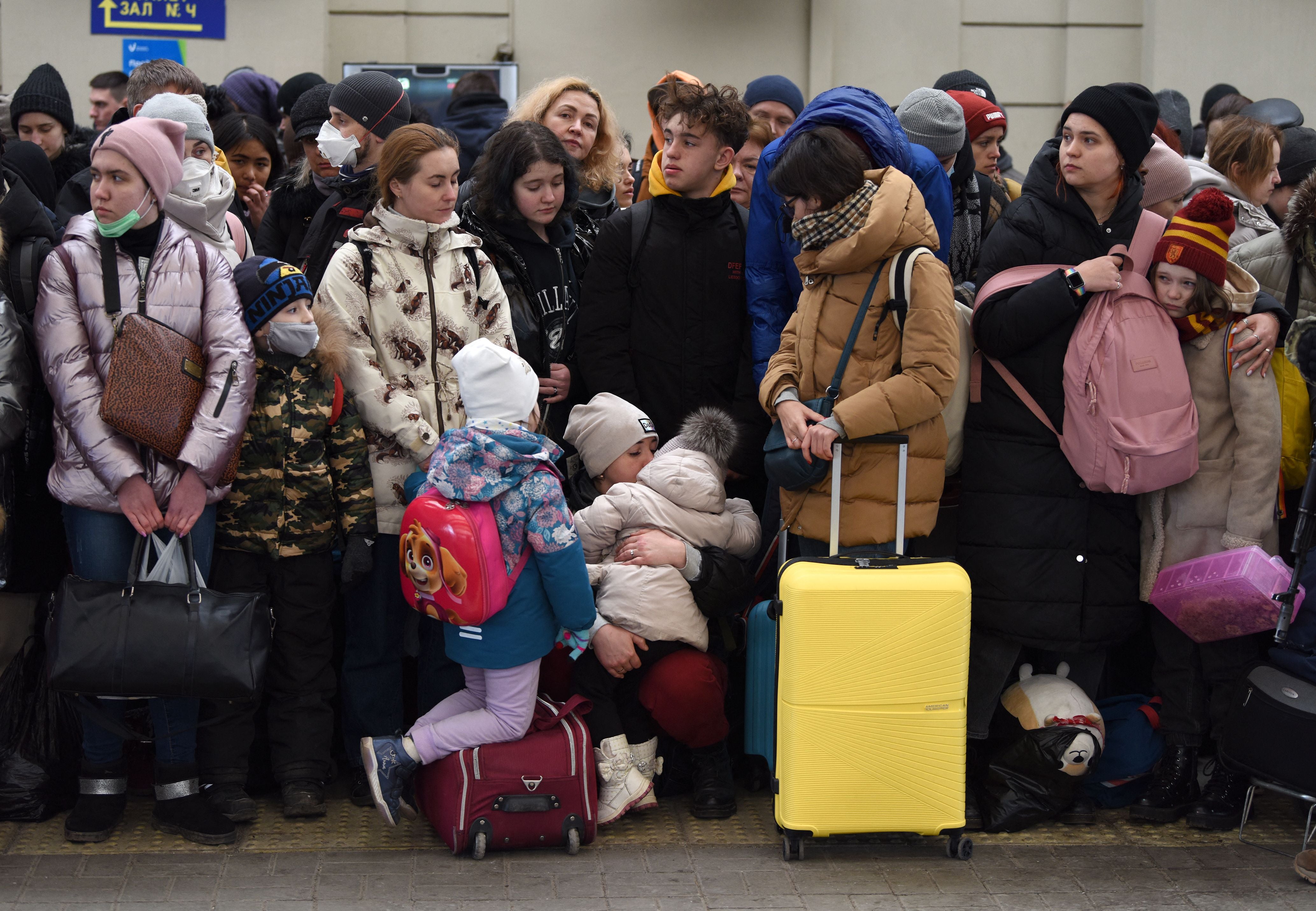 People wait for a train to Poland at the railway station of the western Ukrainian city of Lviv