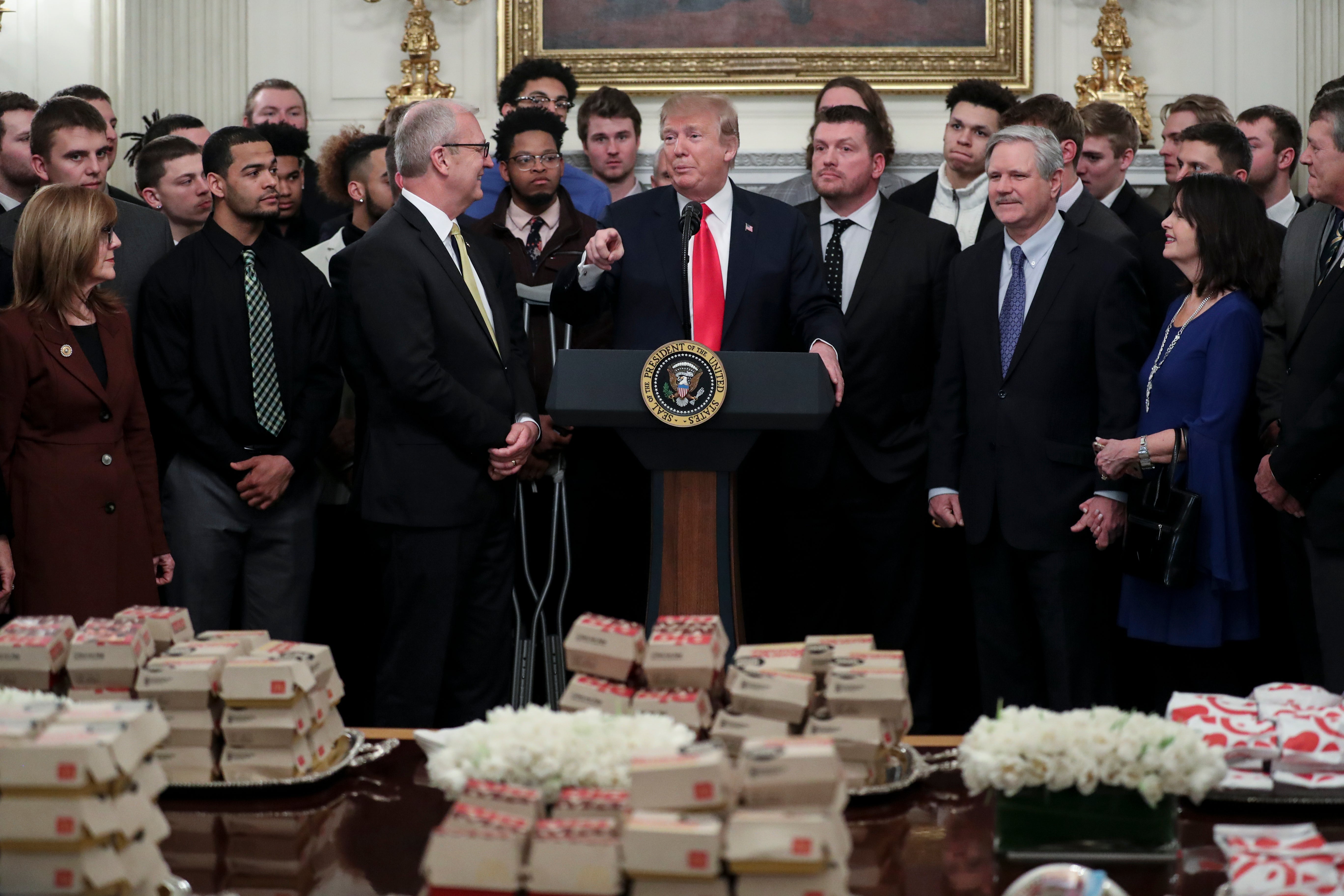 President Donald Trump speaks behind a table full of McDonald's hamburgers, Chick fil-a sandwiches and other fast food as he welcomes the 2018 Football Division I FCS champs North Dakota State Bison in the Diplomatic Room of the White House on March 4, 2019 in Washington, DC