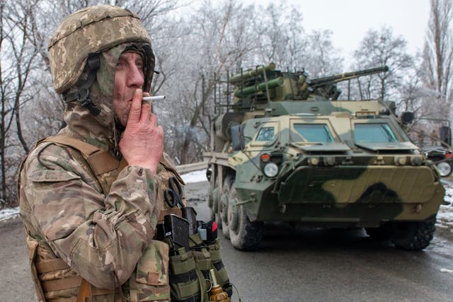 <p>A Ukrainian soldier smokes a cigarette on his position at an armored vehicle outside Kharkiv</p>