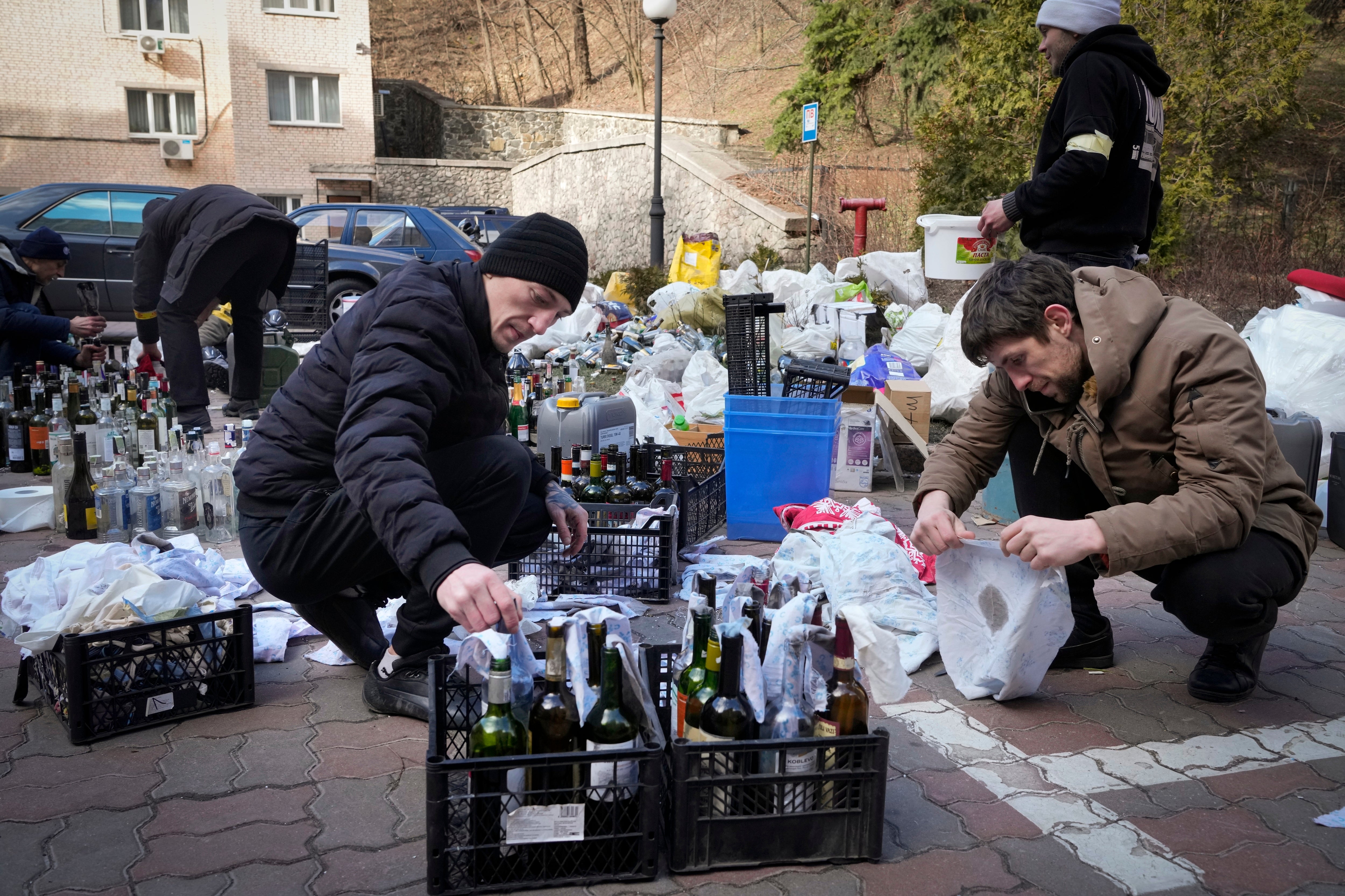 Members of civil defense prepare Molotov cocktails in a yard in Kyiv, Ukraine