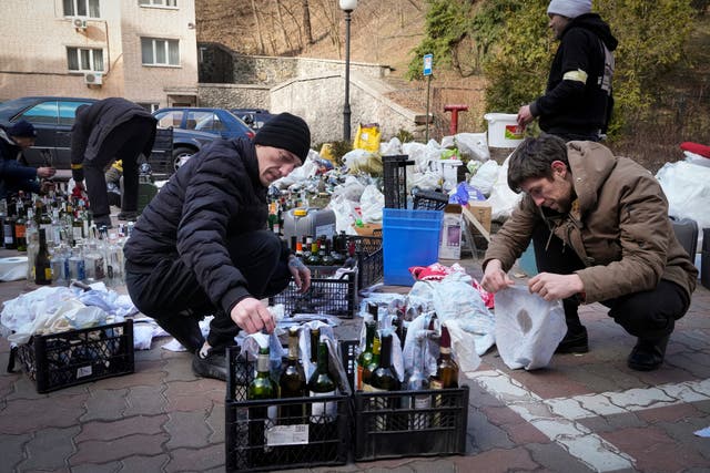 <p>Members of civil defense prepare Molotov cocktails in a yard in Kyiv, Ukraine</p>