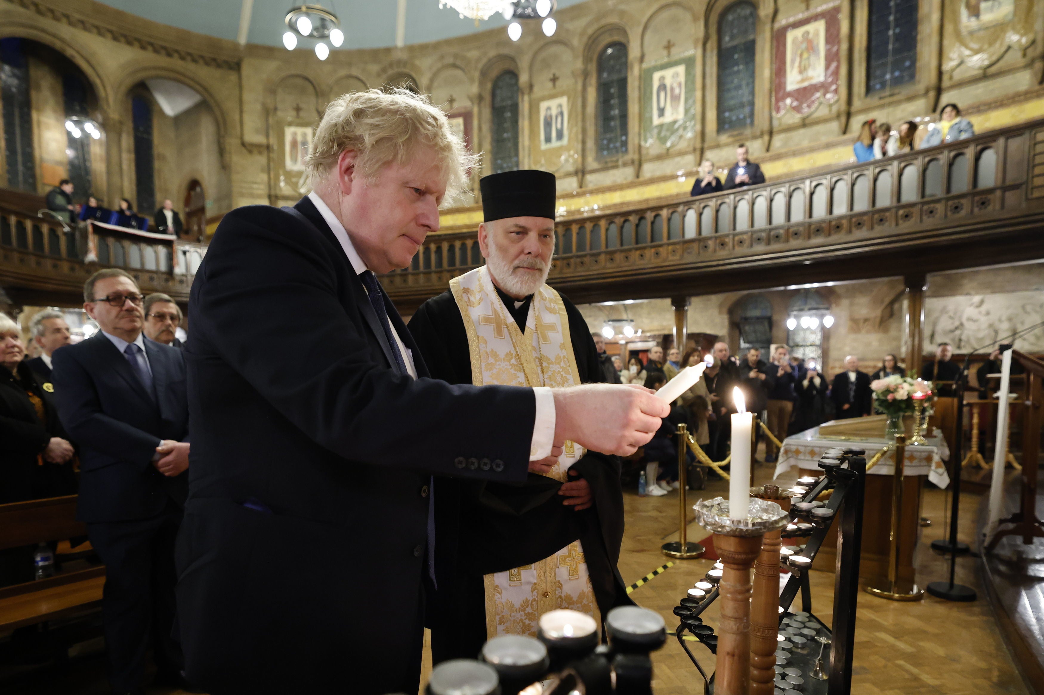 Boris Johnson lights a candle during a visit to the Ukrainian Catholic Eparchy of Holy Family of London