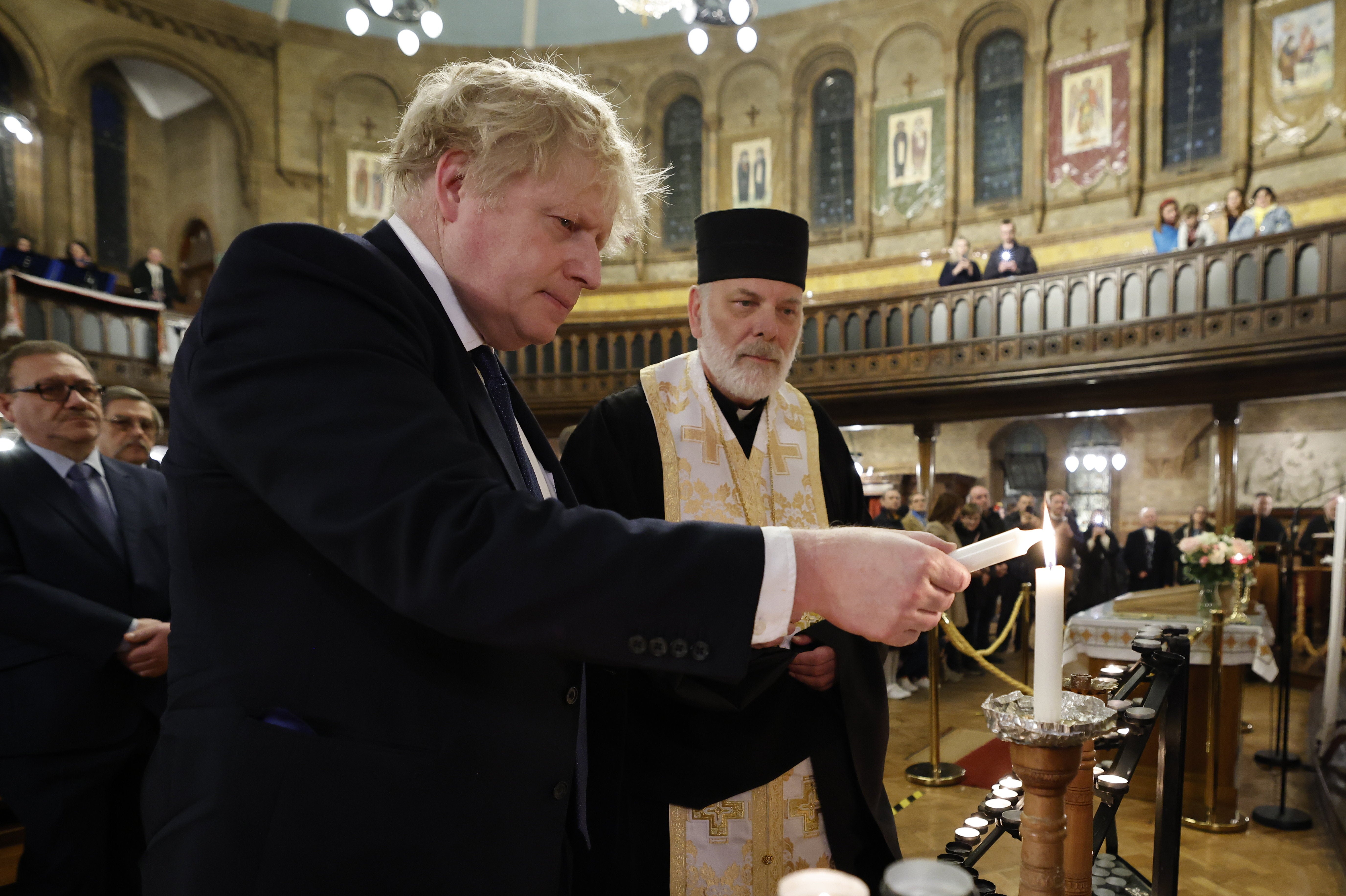 Boris Johnson lights a candle at the Ukrainian Catholic Cathedral in London (Jamie Lorriman/The Daily Telegraph/PA)