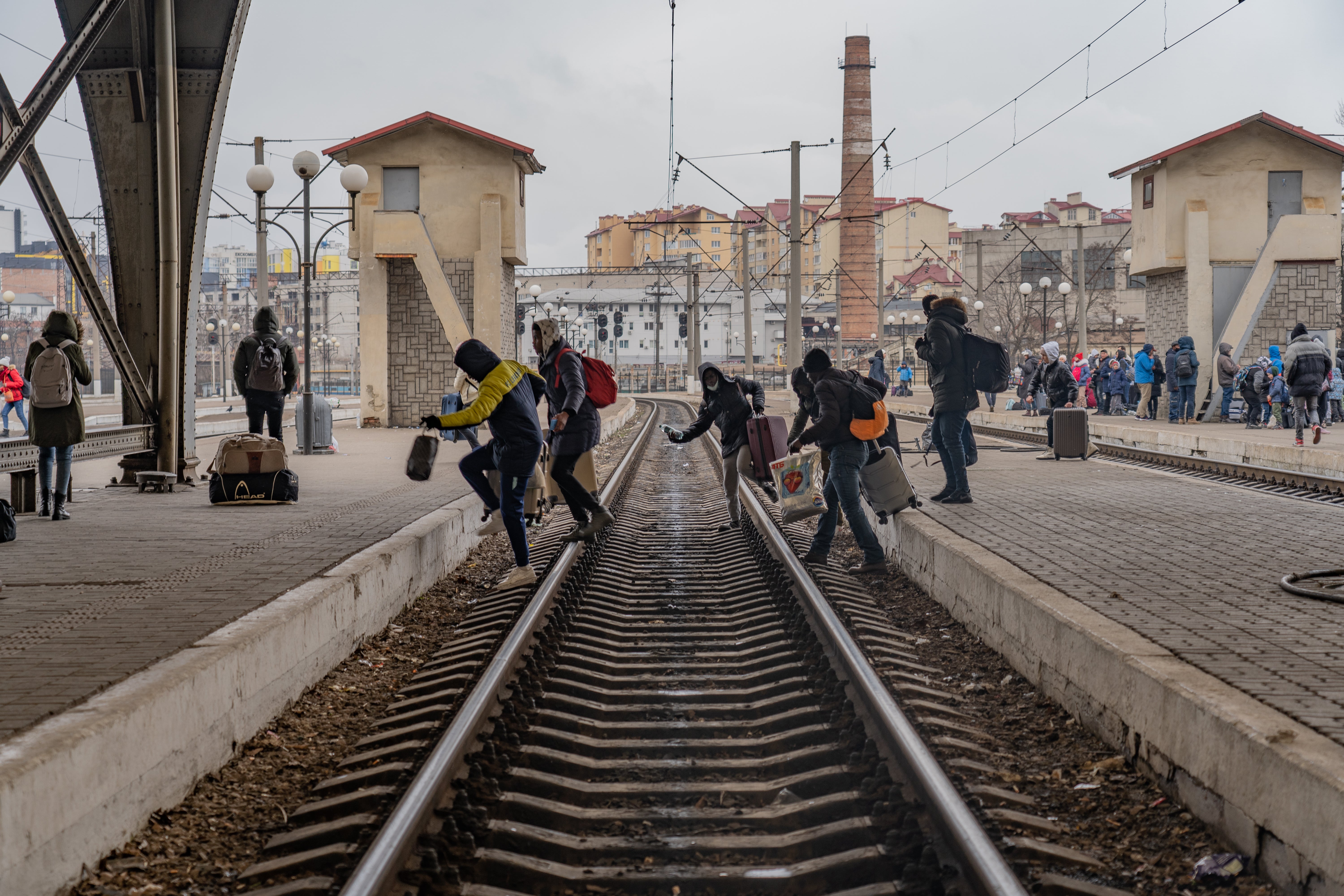 A group of Nigerian refugees move between platforms hoping to catch a train